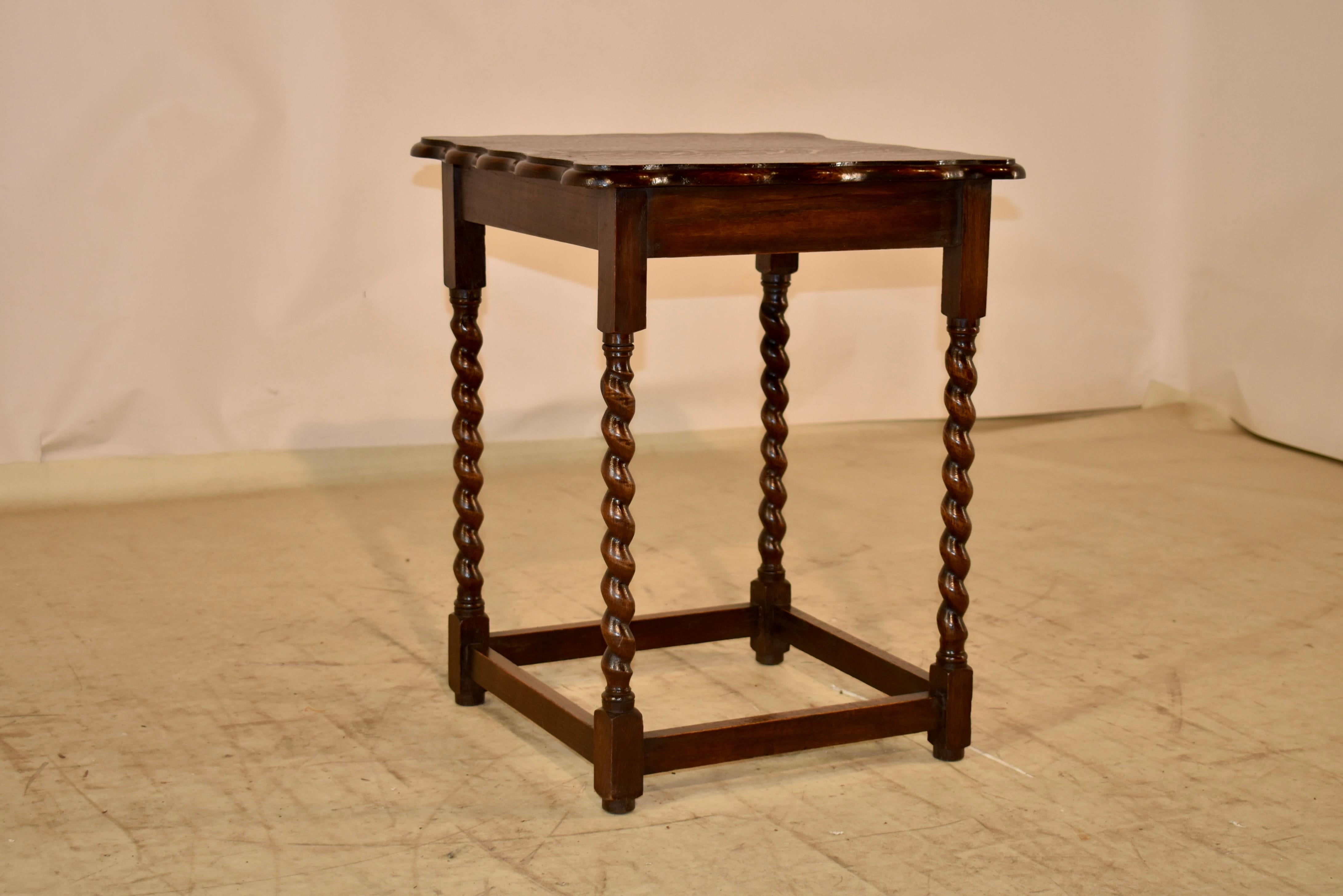 Period Edwardian oak side table from England.  The top has a hand scalloped and beveled edge, following down to a simple apron.  The table is supported on hand turned barley twist legs, joined by simple stretchers and raised on turned feet.