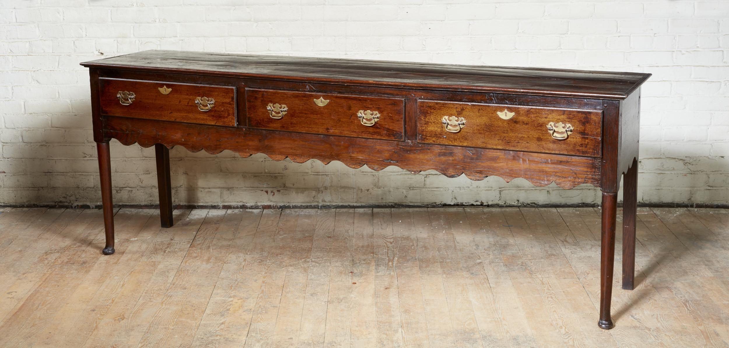 Good English oak pad foot low dresser, the molded top over three drawers over scalloped apron and standing on turned legs ending in pad feet, the whole with good rich color and patination.