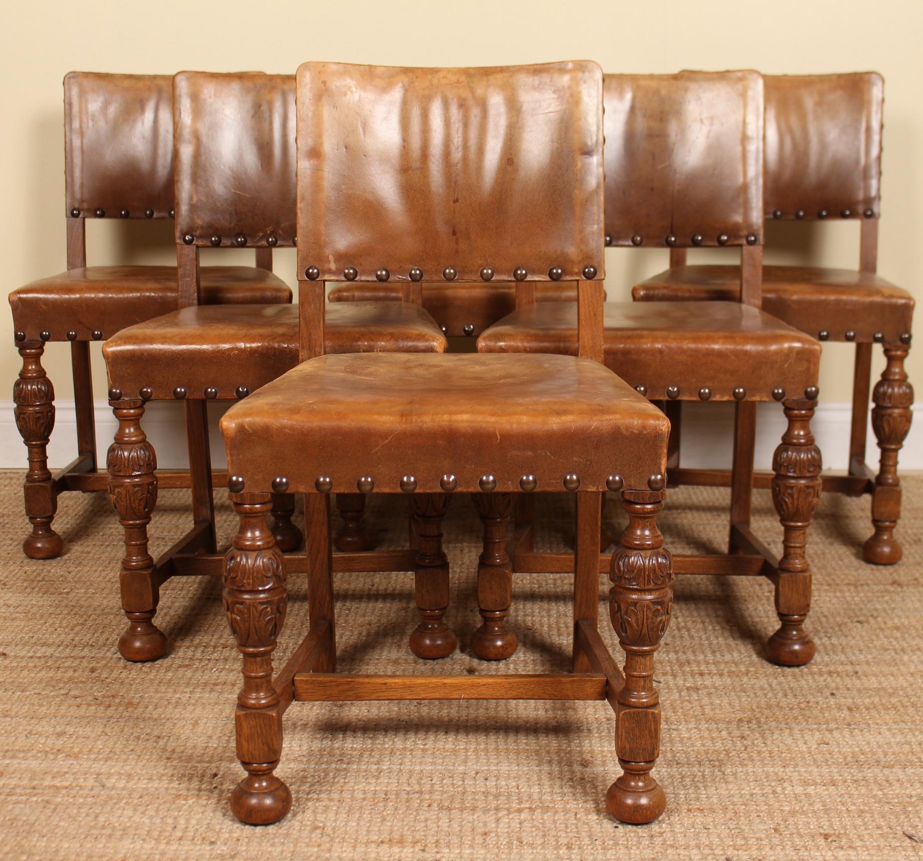 A fine quality early 20th century seven piece oak dining suite.
Constructed from thick cuts of fine solid oak boasting a well figured wild honey tone grain.

The dining chairs upholstered in genuine tan leather with studded borders and raised on