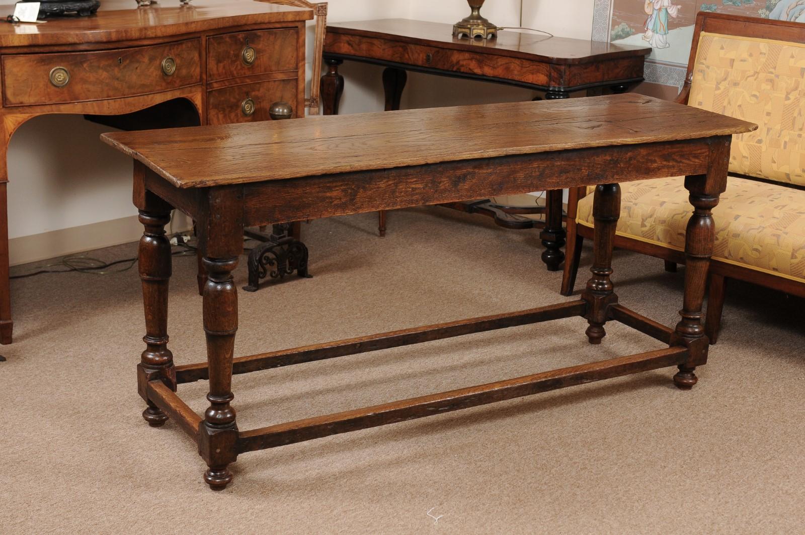 An English oak refectory table dating from the mid-19th century with turned legs and box stretcher.