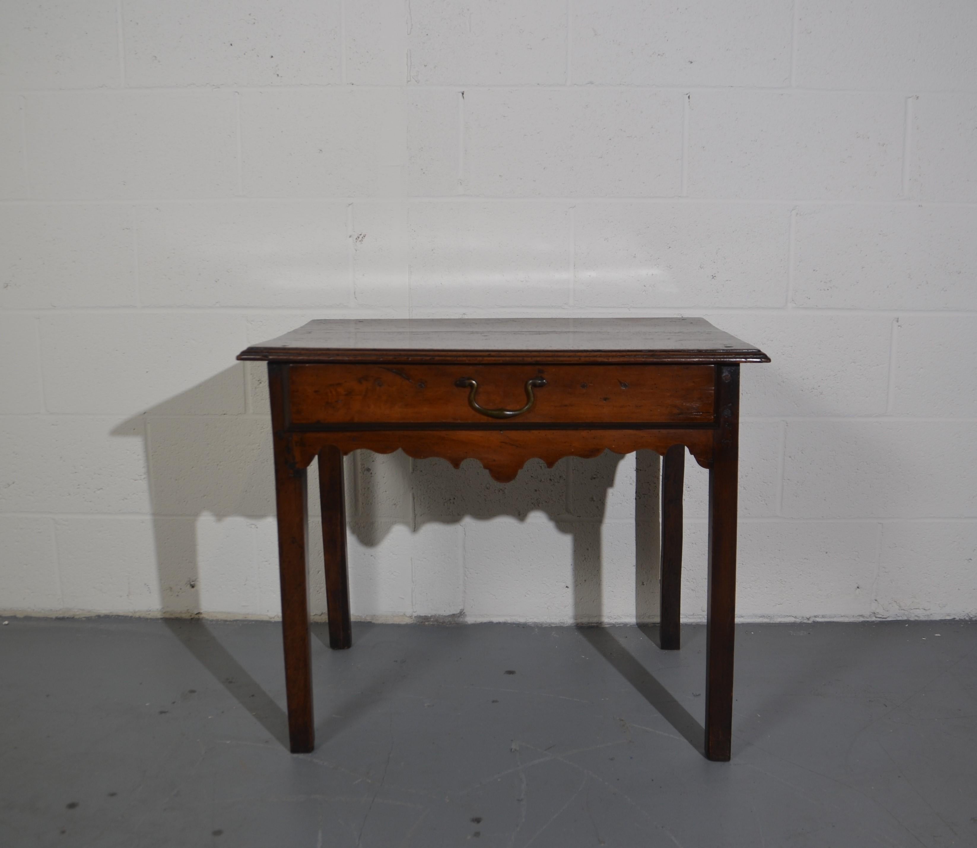 This is a 220 year old English Oak Side Table. An undulating carved frieze and a single drawer with Swan-Neck Hardware. An original survivor with multi-uses.