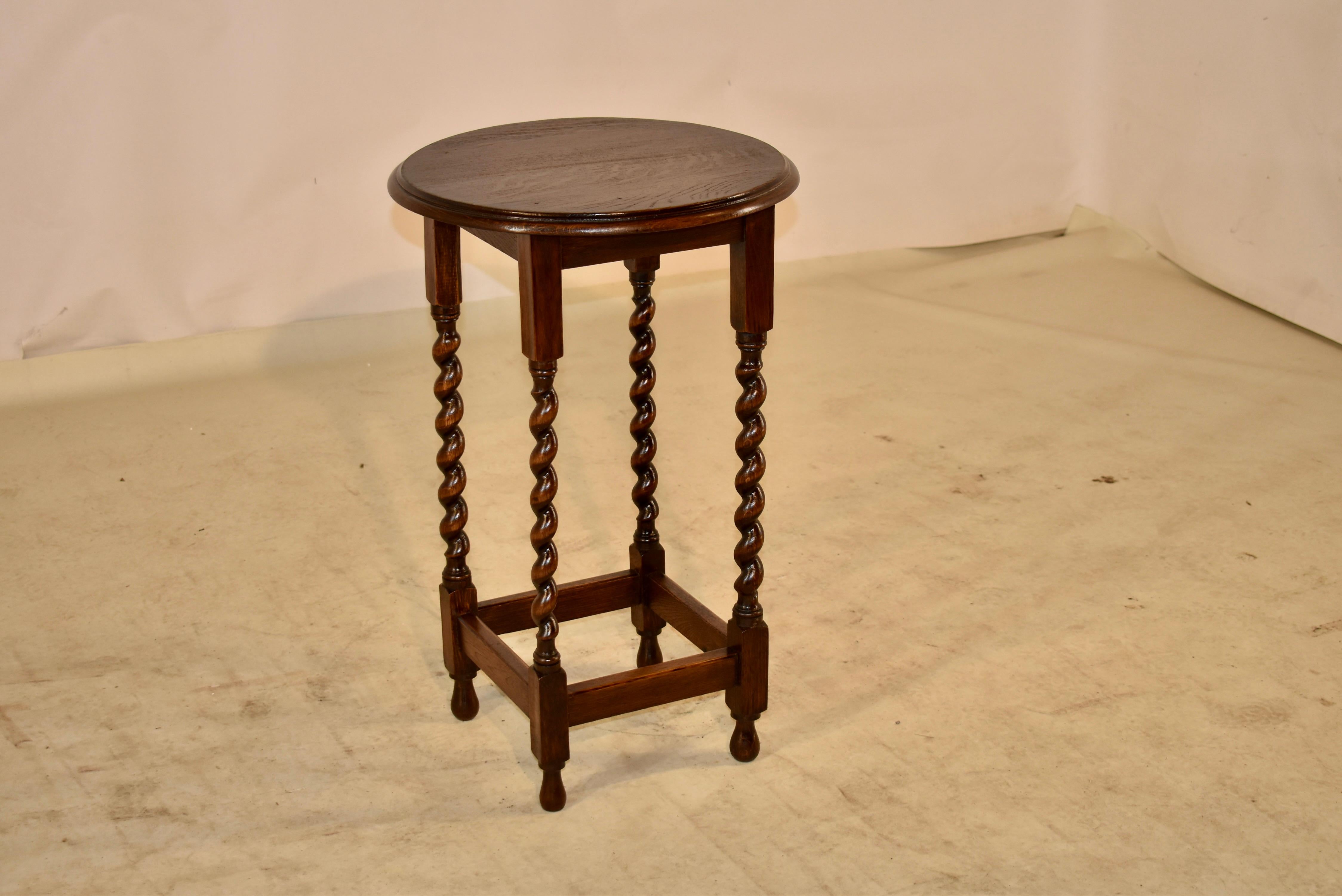 Edwardian oak side table, circa 1900. The top is round and has a beveled edge, following down to a simple apron and is supported on hand turned barley twist legs, joined at the bottom by simple stretchers. The table is raised on hand turned feet.
