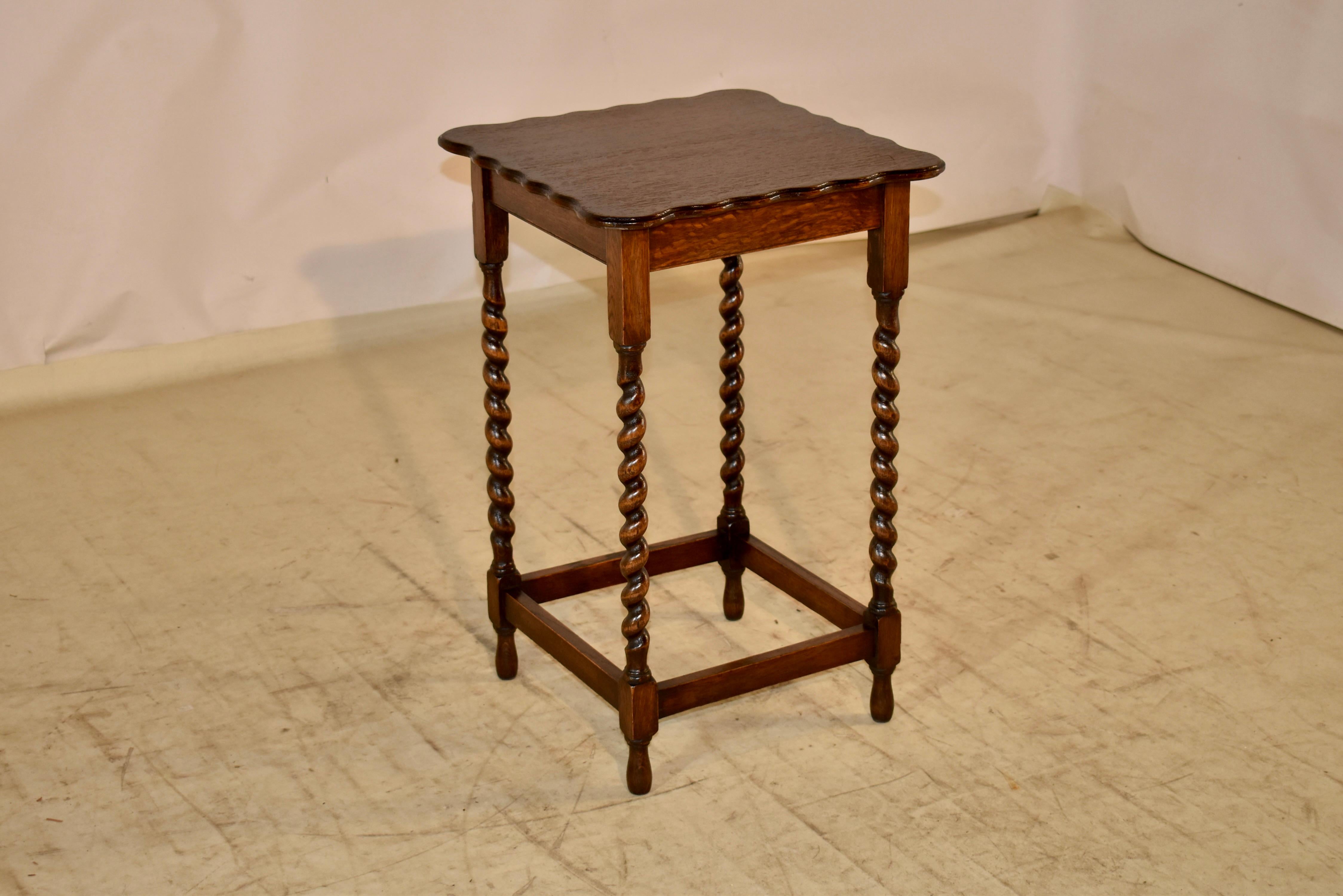 Period Edwardian oak side table from England.  The table is square and the top has a beveled and scalloped edge,  following down to a simple apron. The table is supported on hand tuned barley twist legs, joined by simple stretchers and raised on
