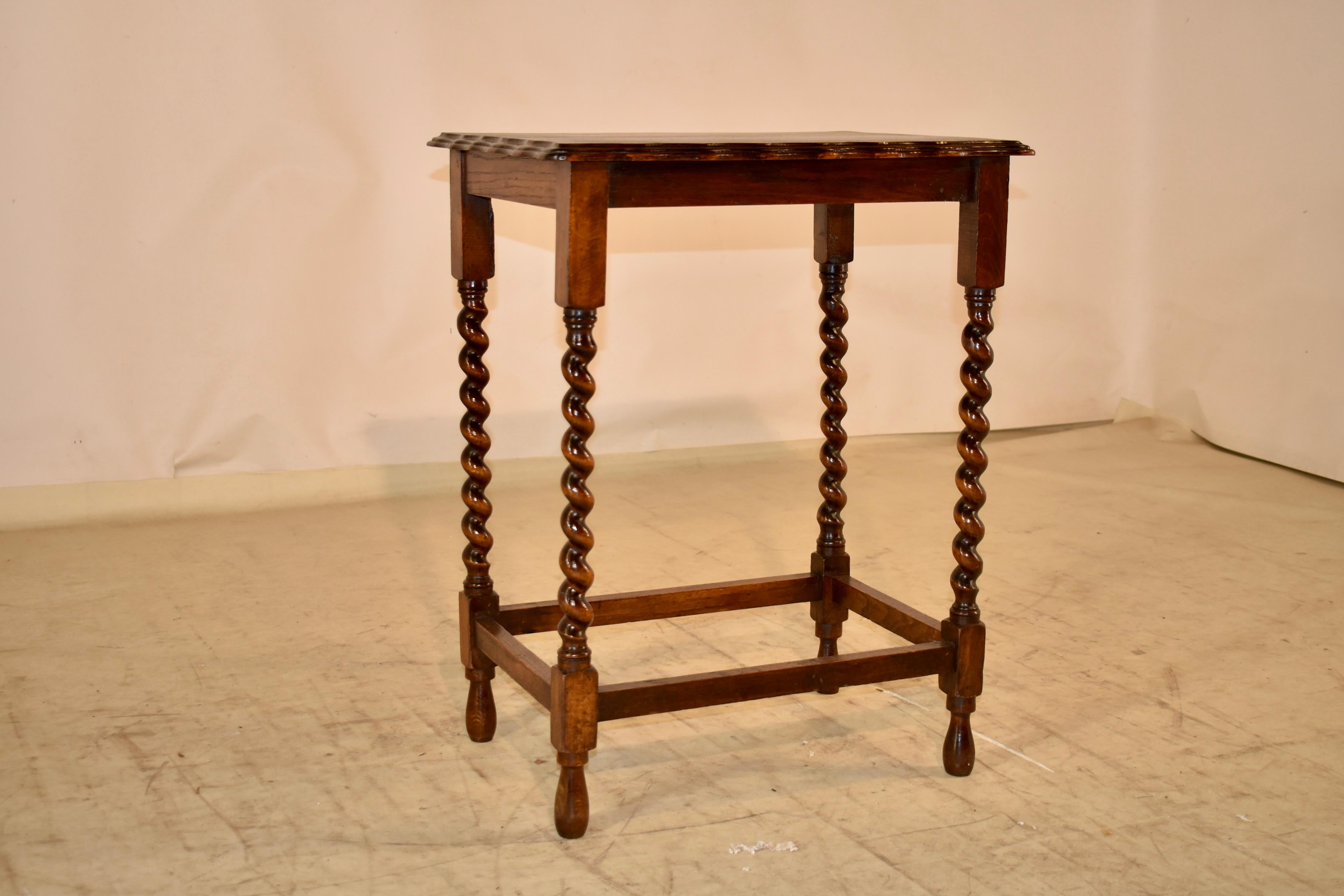 Edwardian oak side table from England, circa 1900-1909.  The top has a gorgeous scalloped and double beveled edge, following down to a simple apron.  The table is supported on hand turned barely twist legs, joined by simple stretchers.  The table is