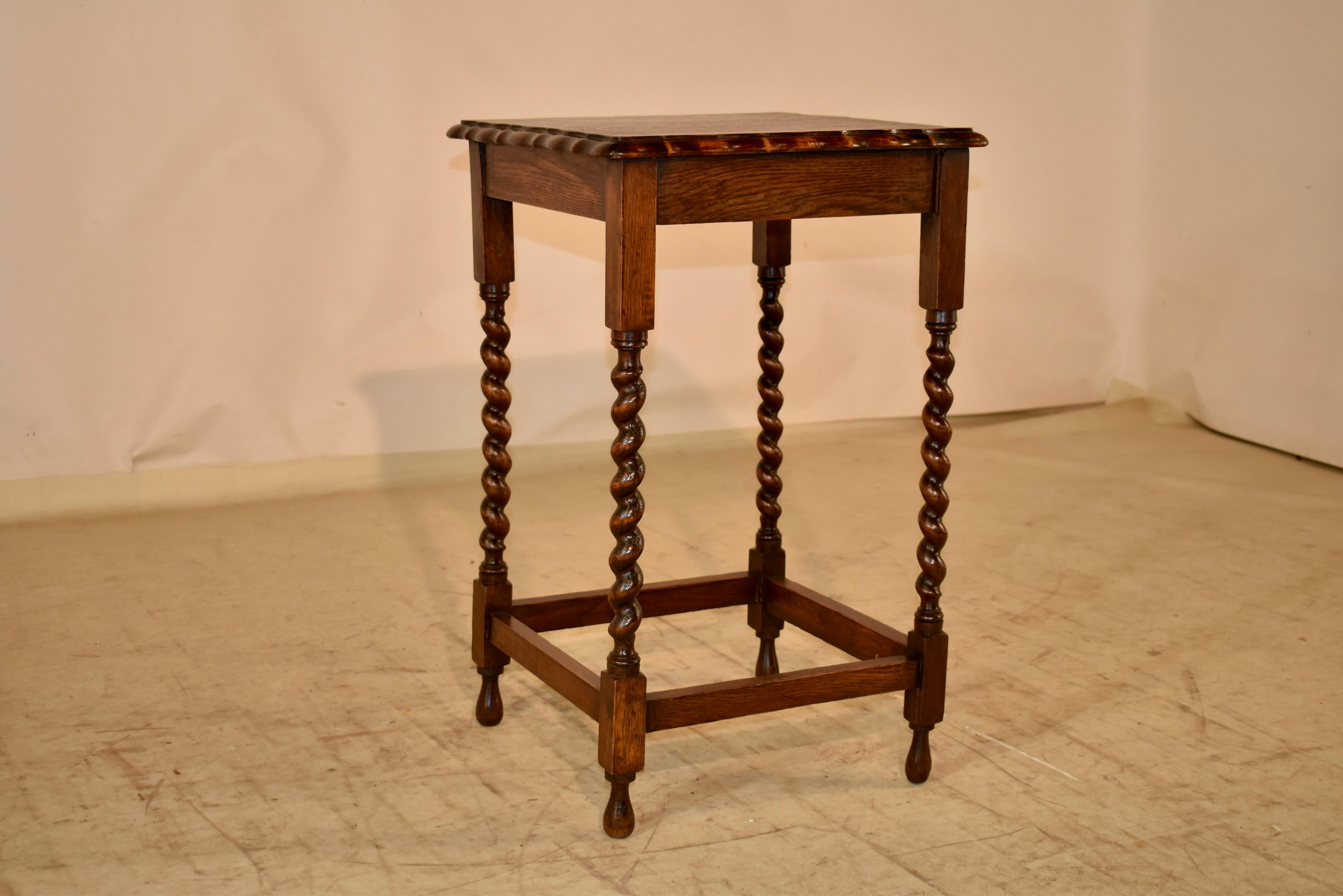 English oak side table, circa 1900.  The top has a beveled edge surrounding a nicely grained top.  The top follows down to a simple apron and is supported on hand turned barely twist legs, joined by simple stretchers.  The table is raised on hand