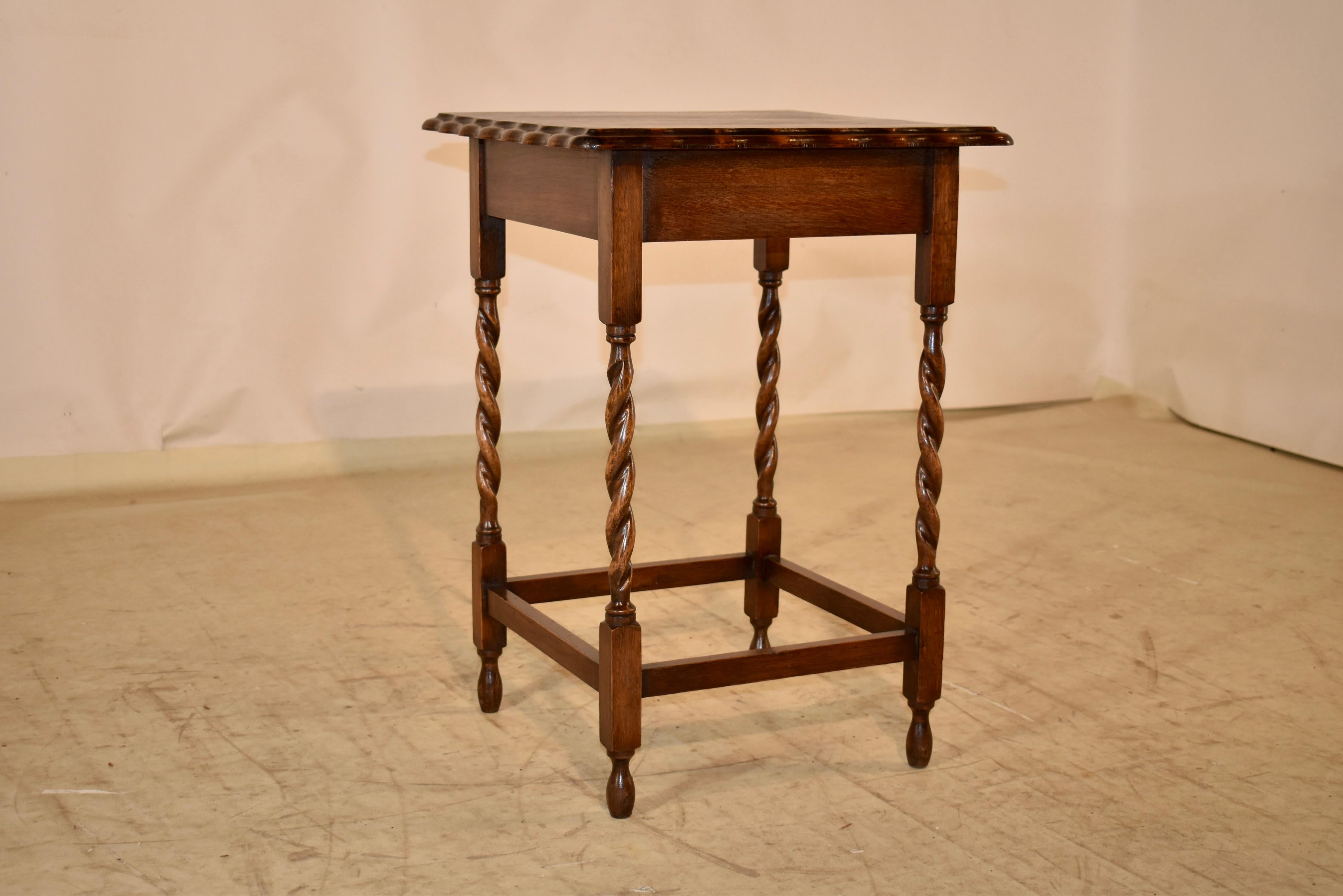 Circa 1900 Edwardian oak side table from England.  The top has a scalloped and beveled edge surrounding a wonderfully grained top.  This follows down to a simple apron and is supported on hand turned barley twist legs, joined by simple stretchers