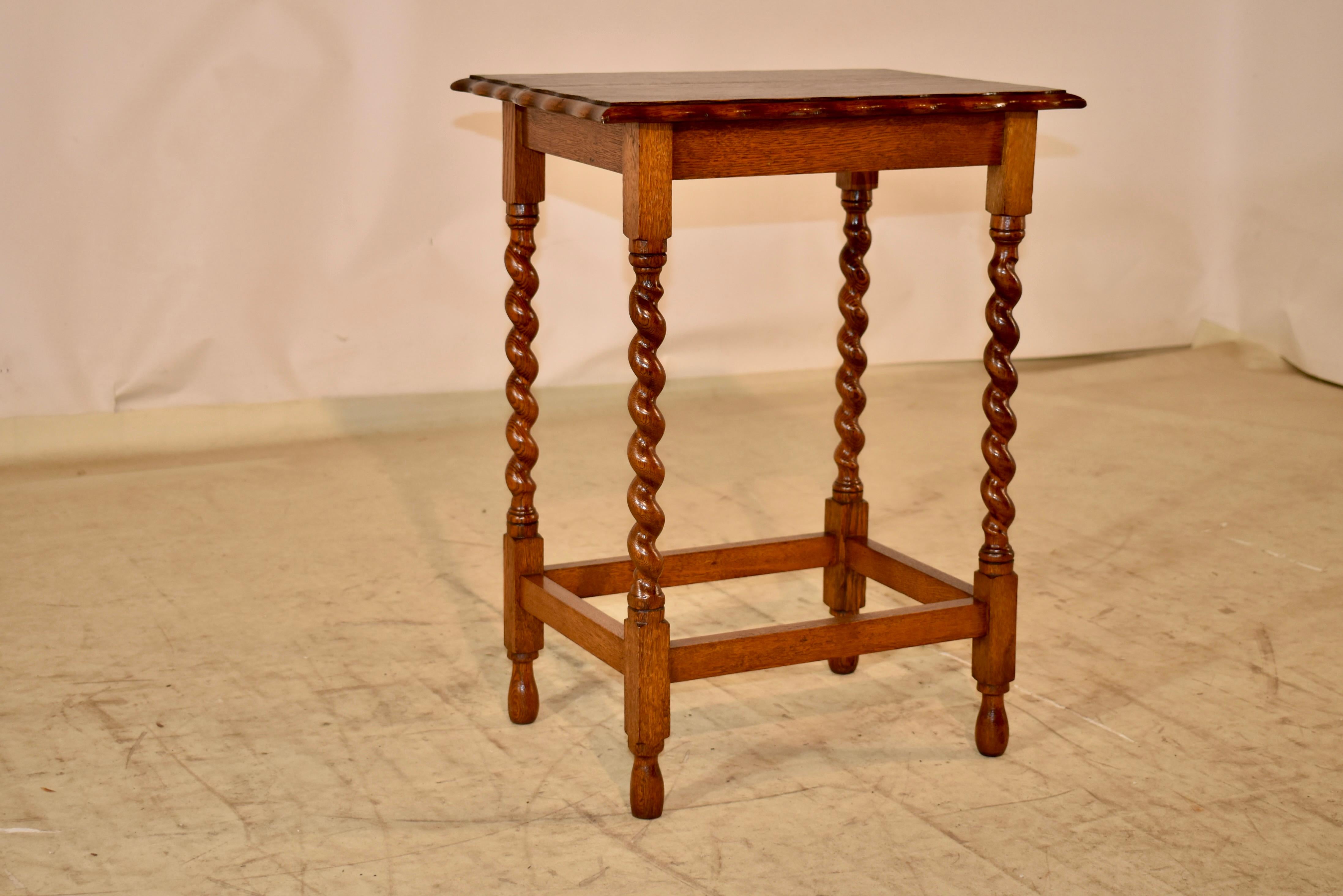 Period Edwardian oak side table from England.  The top is handsomely beveled and scalloped , and follows down to a simple apron.  The table is supported on hand turned barley twist legs, joined by simple stretchers and raised on hand turned feet.