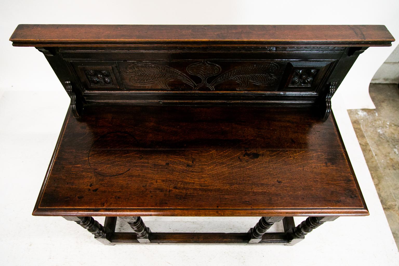 The lower section of this English oak side table was likely reconstructed from an early English gate leg table. The table top and carved back gallery were constructed in the late 19th century on top of the earlier gate leg table base.
 