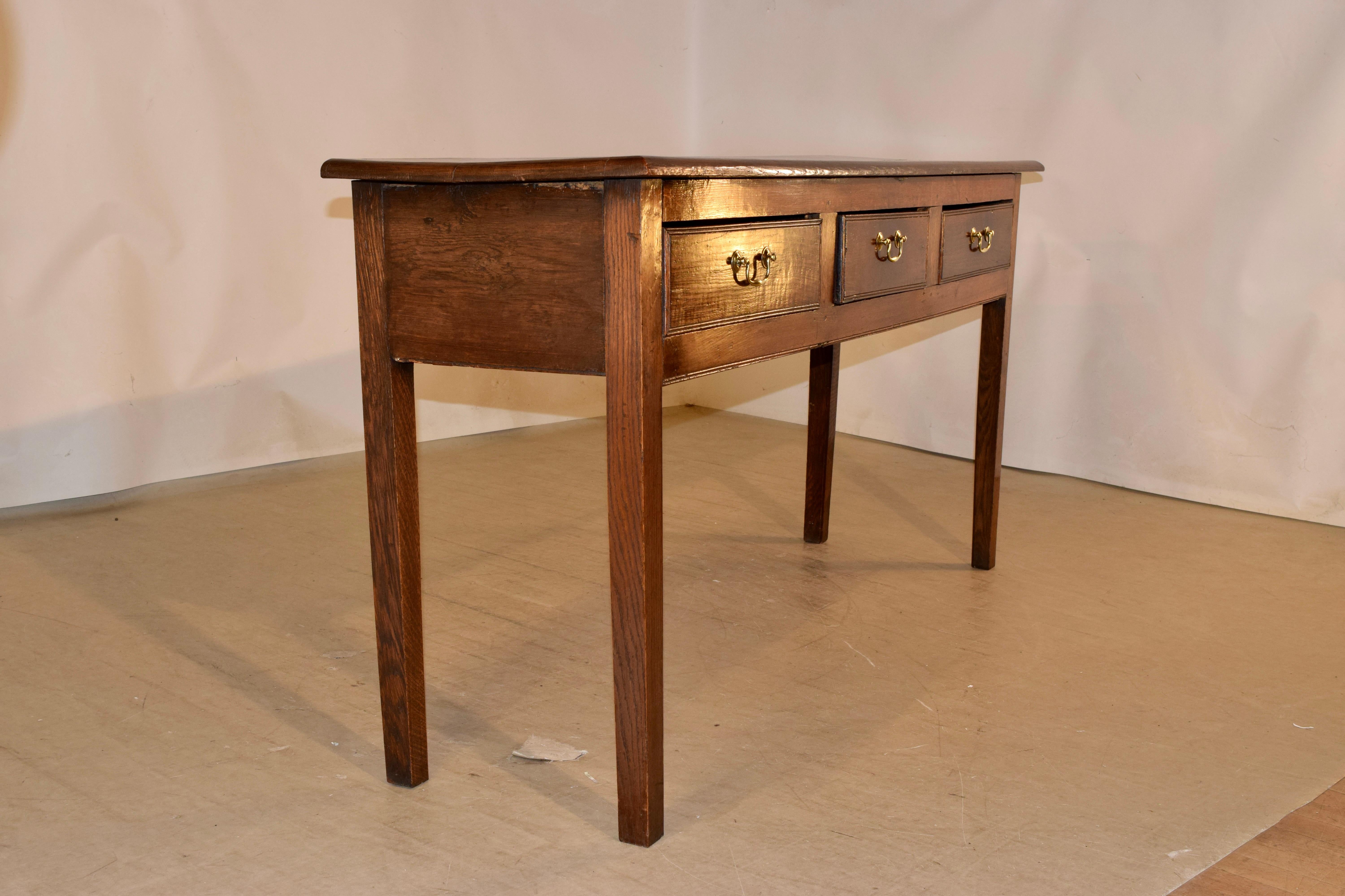 Circa 1900 oak sideboard from England with simple and elegant lines. The top is made from two boards, following down to a simple apron, containing three drawers in the front and supported on slightly tapered legs.