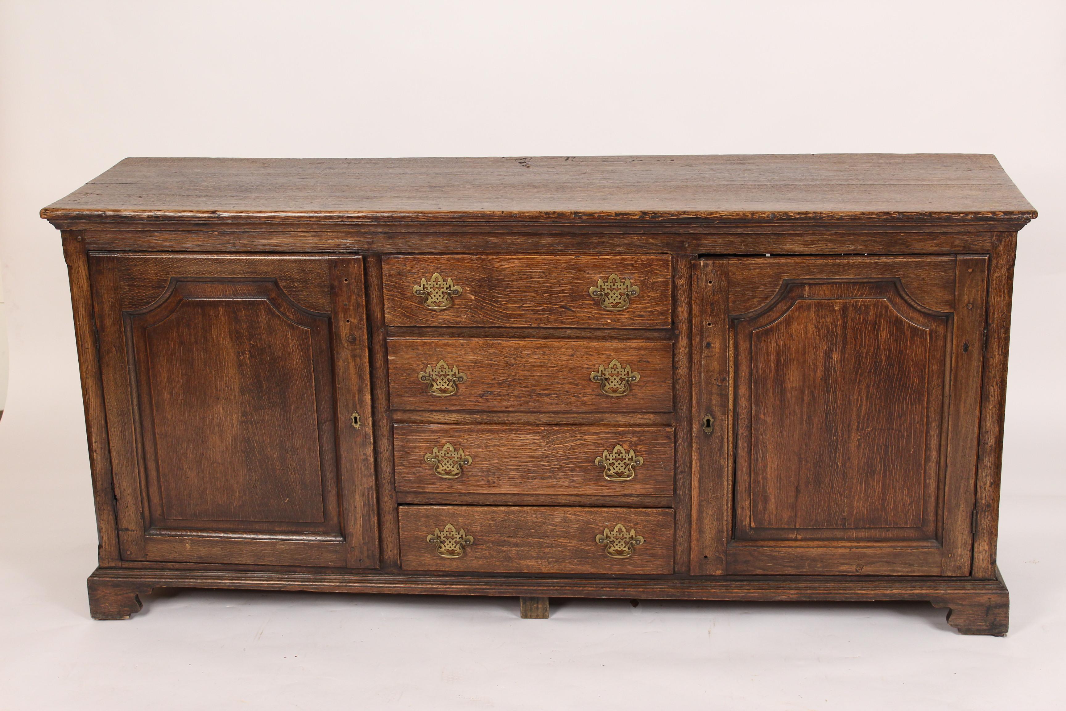 Antique English oak sideboard with two cupboard doors and 4 drawers, 19th century.