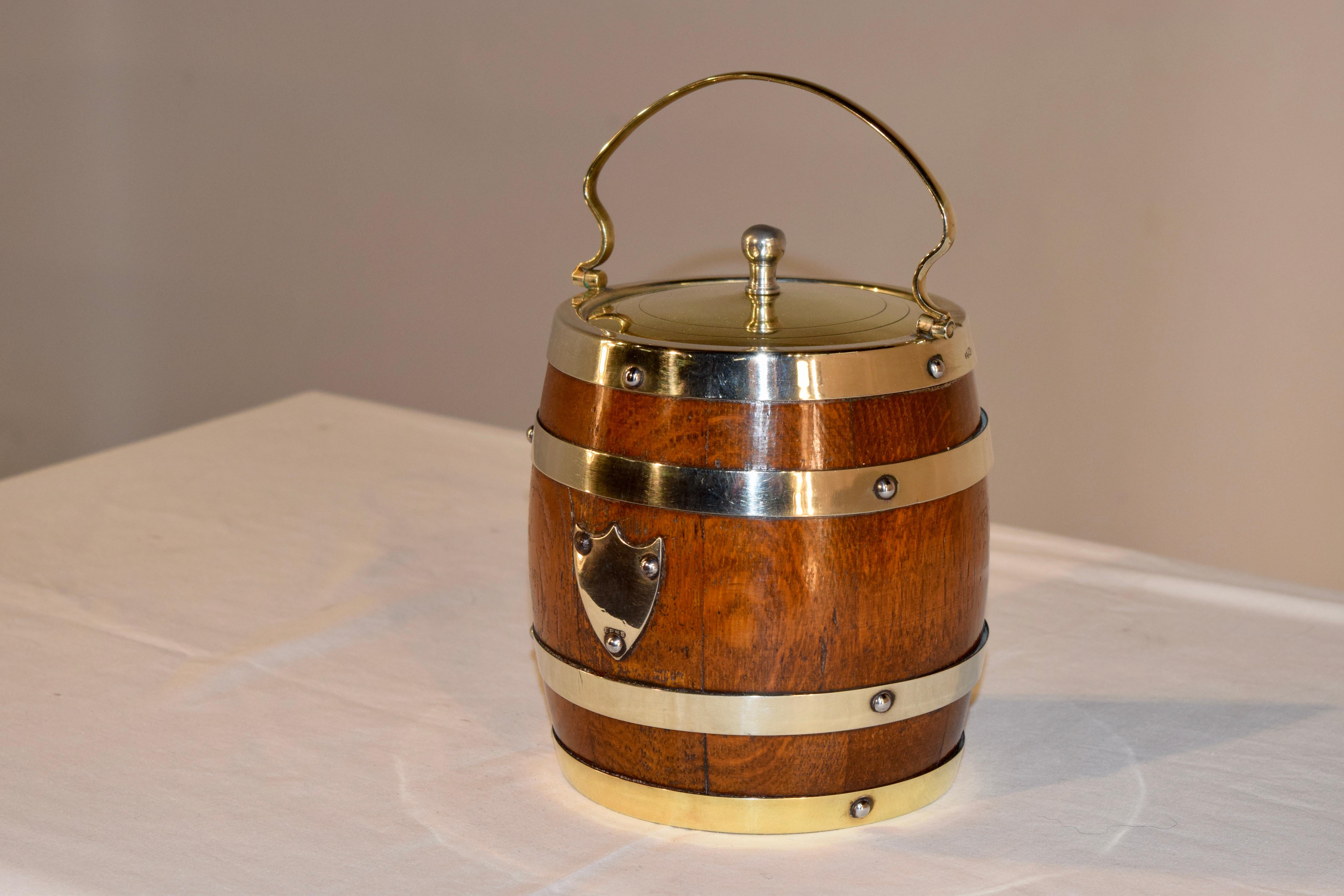 English oak biscuit barrel with silver plated lid and banding. It retains the original porcelain liner inside.
  