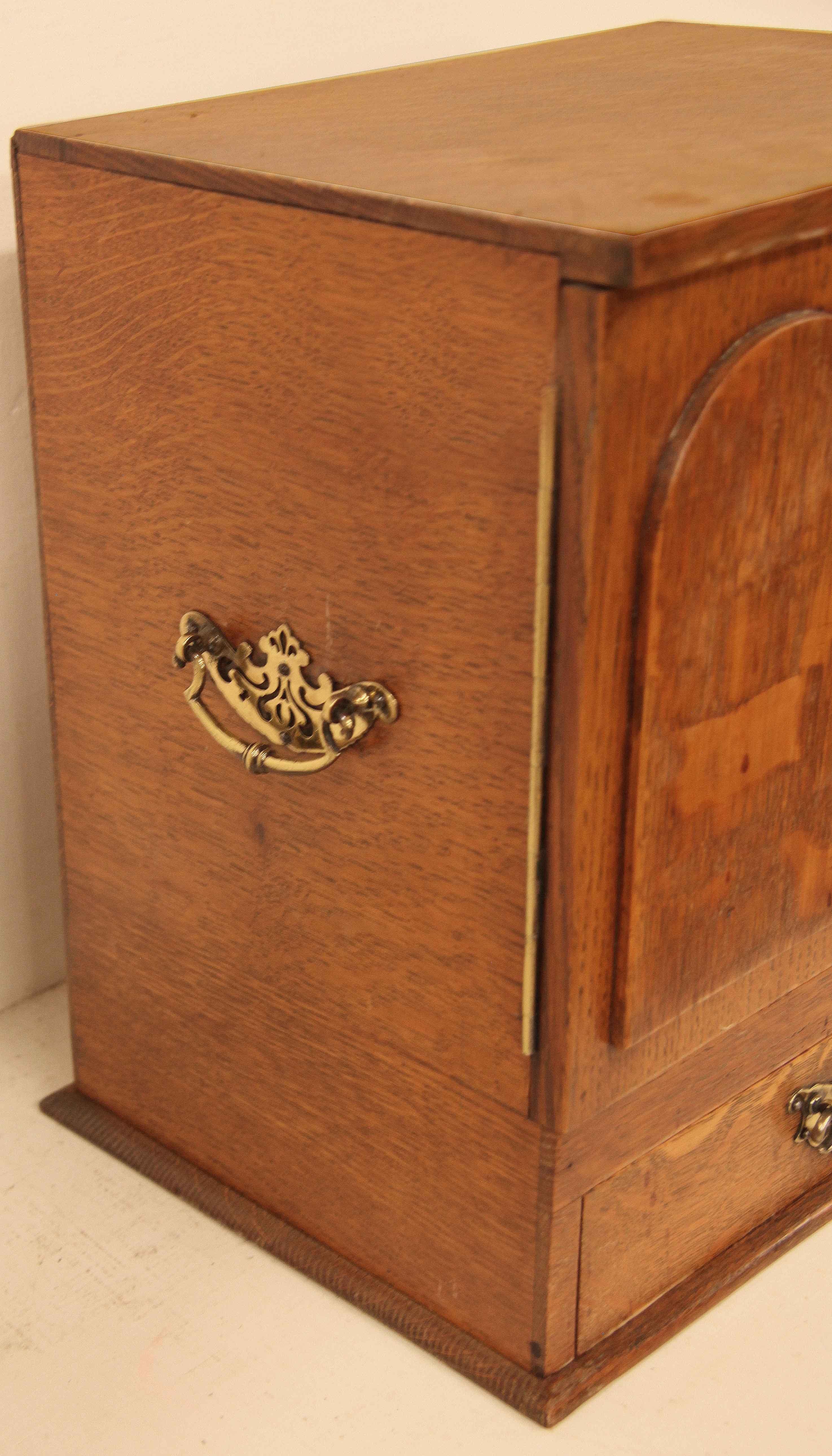 English oak smoker's cabinet, the top and doors were selected to have quarter sawn oak, the more decorative cut than straight grain oak. The sides have carrying handles.  Opening the two raised panel doors reveals two drawers ;  the exterior bottom