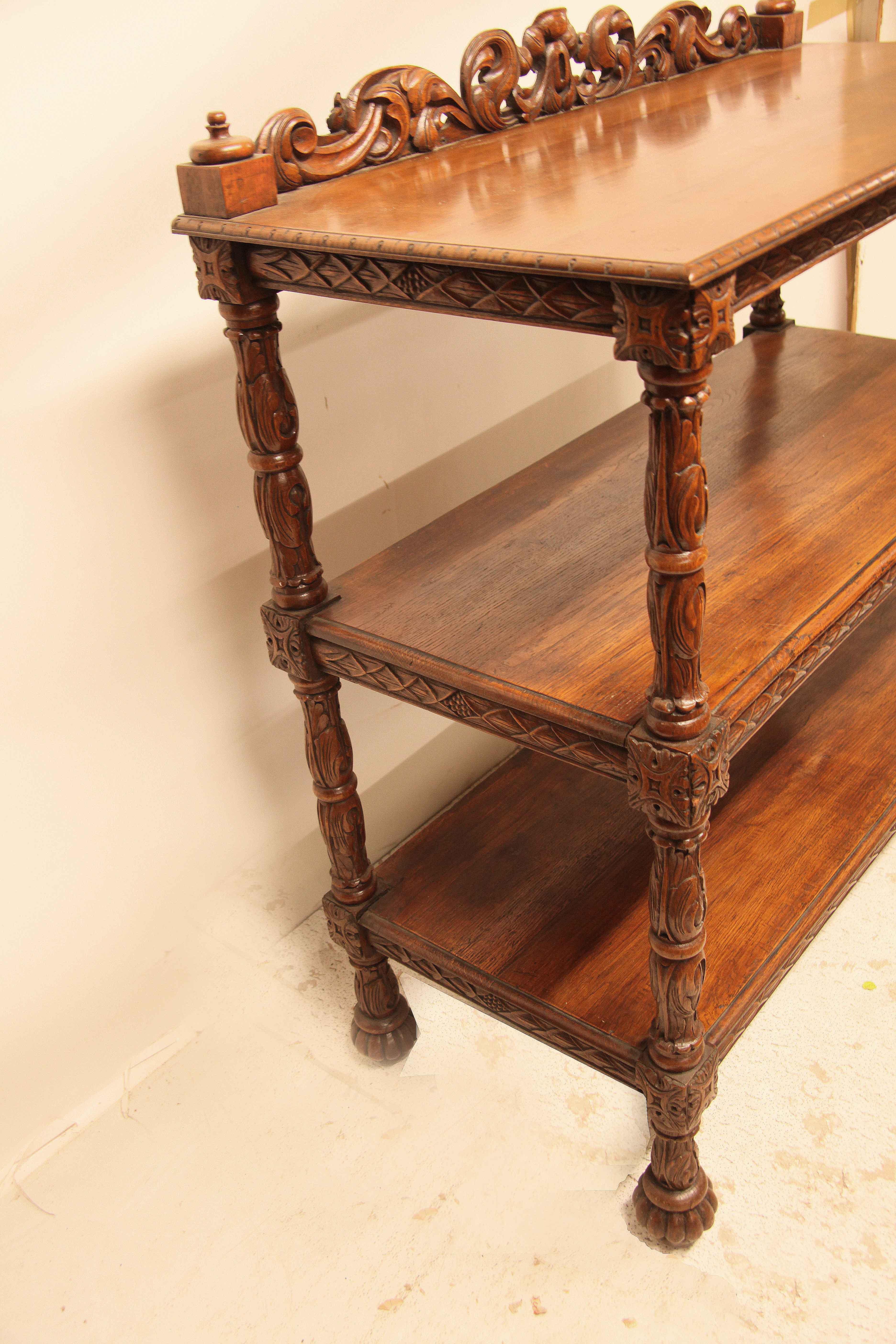 English carved oak three tier server,  the carved gallery (which adds an additional 4.5'' to the published height) features intertwined arabesques, the two shelves and top with ''diamond'' carved horizontal supports,  the four vertical stiles have