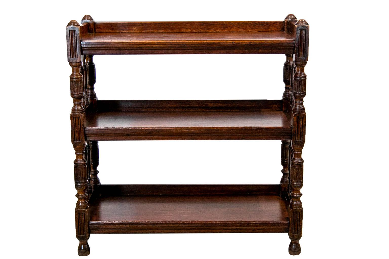 All three shelves of this tiered server have a gallery on three sides. The sides are elaborately carved with fluted hand molded panels and fluted support columns with six turned decorative spindles on each side.