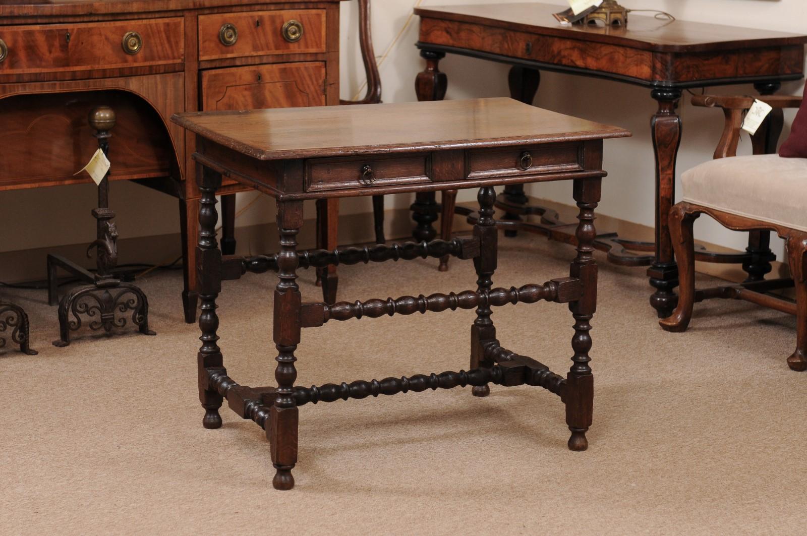 An English oak side table featuring rectangular top, single drawer in frieze, turned legs joined by 2 stretchers and H-form stretcher below ending in turned feet. 

 