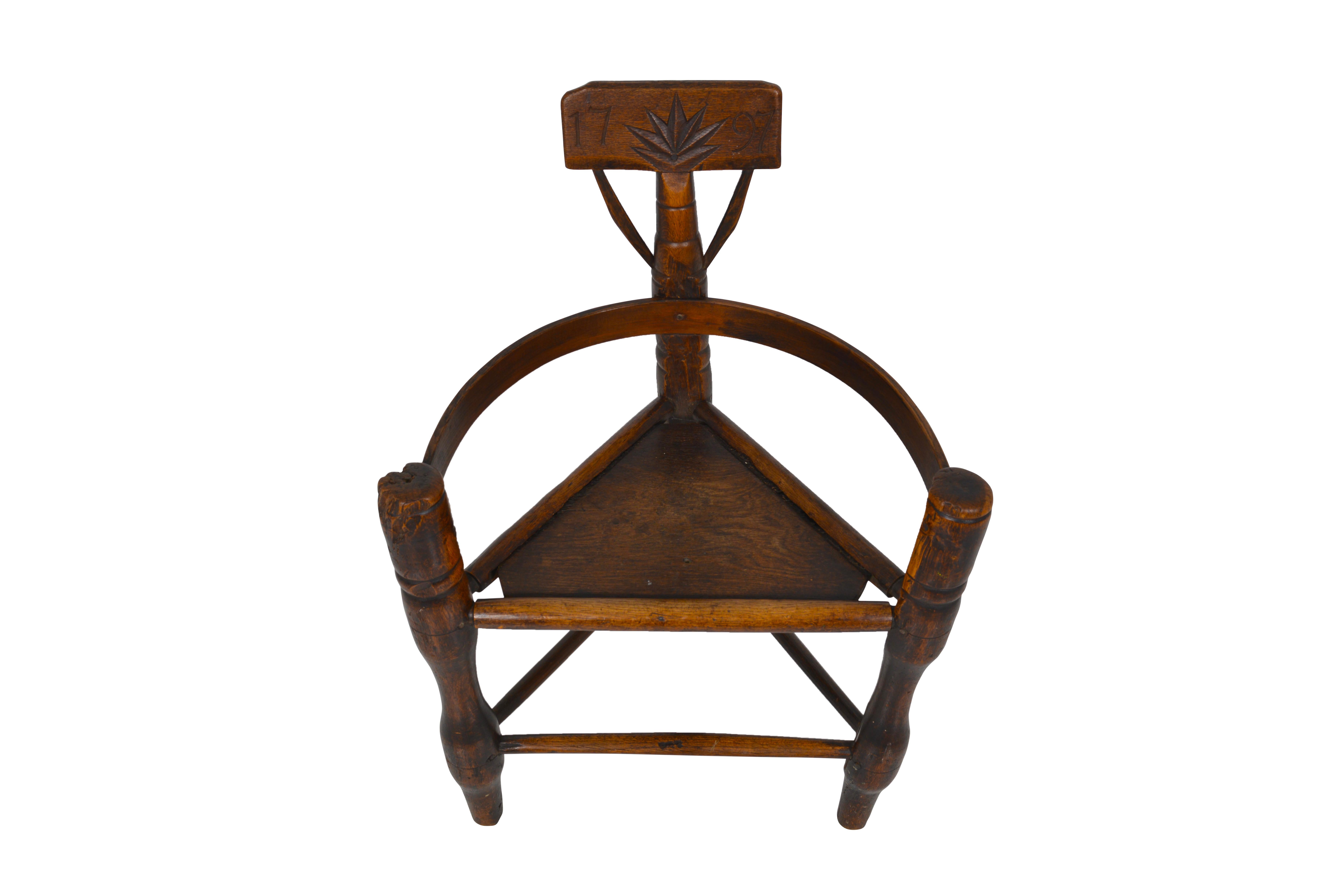 Triangular three-legged primitive chair called Turners’ Chair. Made from English oak, this chair has good color and patina. Turners’ chairs were made by wood turners in pre-Elizabethan age before joiners took over furniture making from turners and