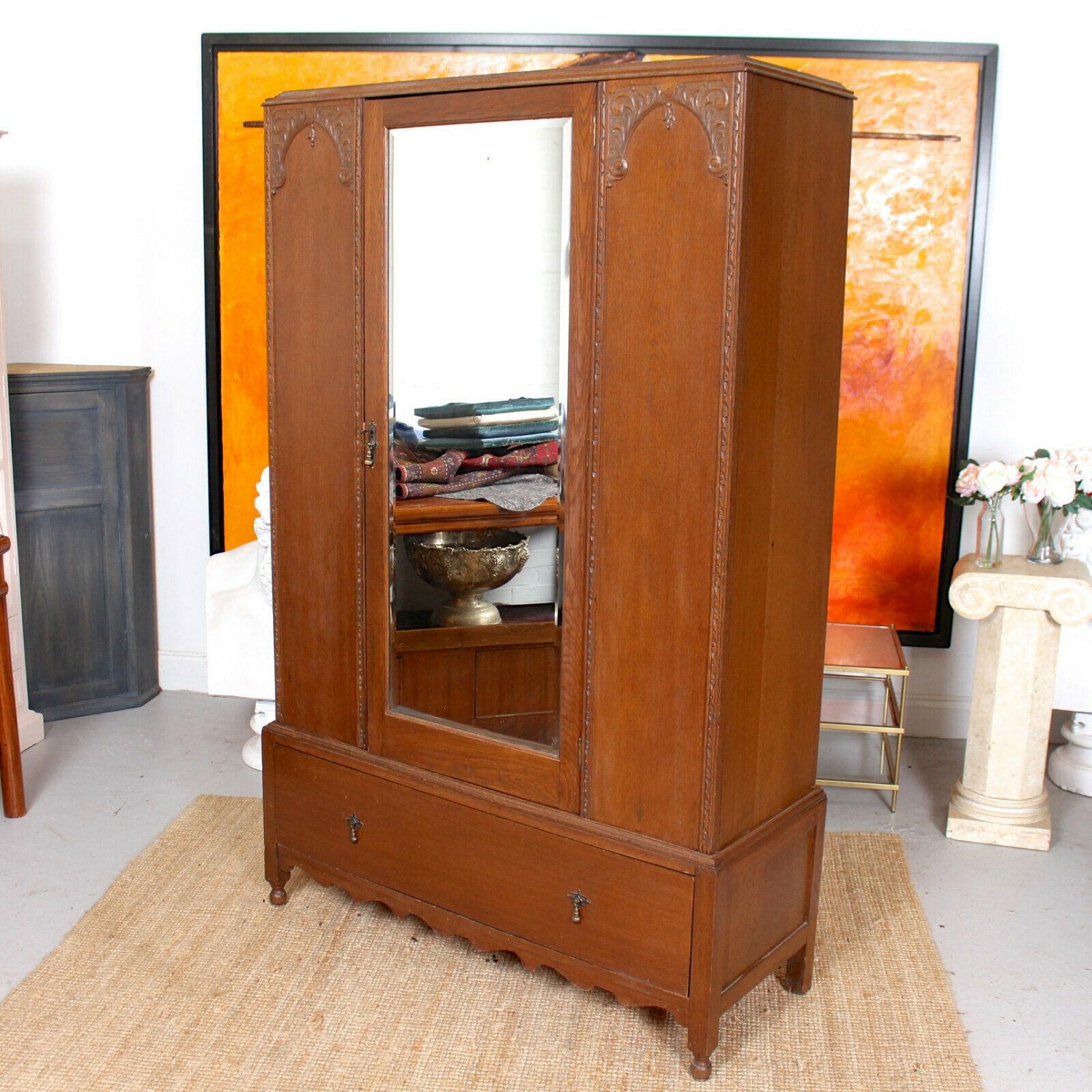 An impressive 19th century carved oak wardrobe in the Arts & Crafts manner.

A beveled mirror paneled door flanked by beaded panels and enclosed hanging rails and storage. Fitted a drawer to based and raised on carved bun feet.
   