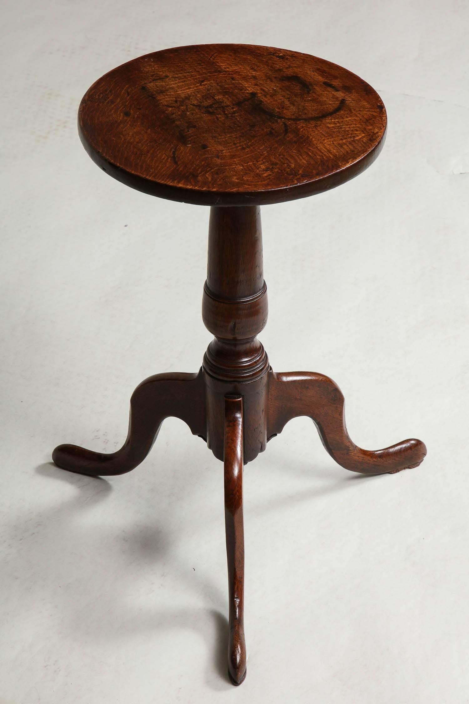 Fine 18th century English oak wine table or kettle stand having circular top with simple bullnose edge over boldly turned shaft and standing on well formed cabriole legs ending in slipper feet.