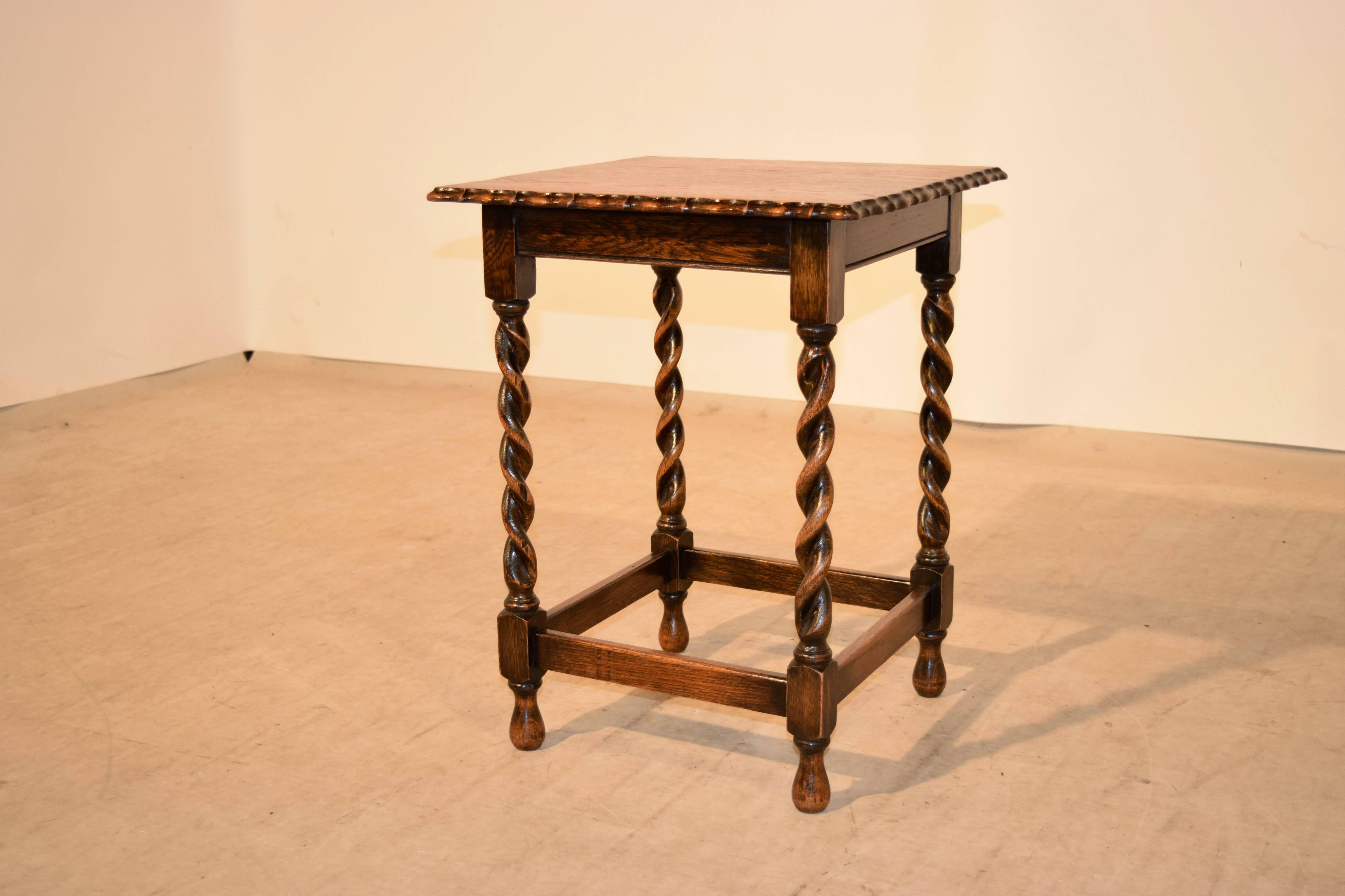 English oak occasional table, circa 1900. The top has a scalloped and beveled edge, and follows down to a simple apron and hand-turned barley twist legs which are joined by simple stretchers and raised on hand-turned feet.