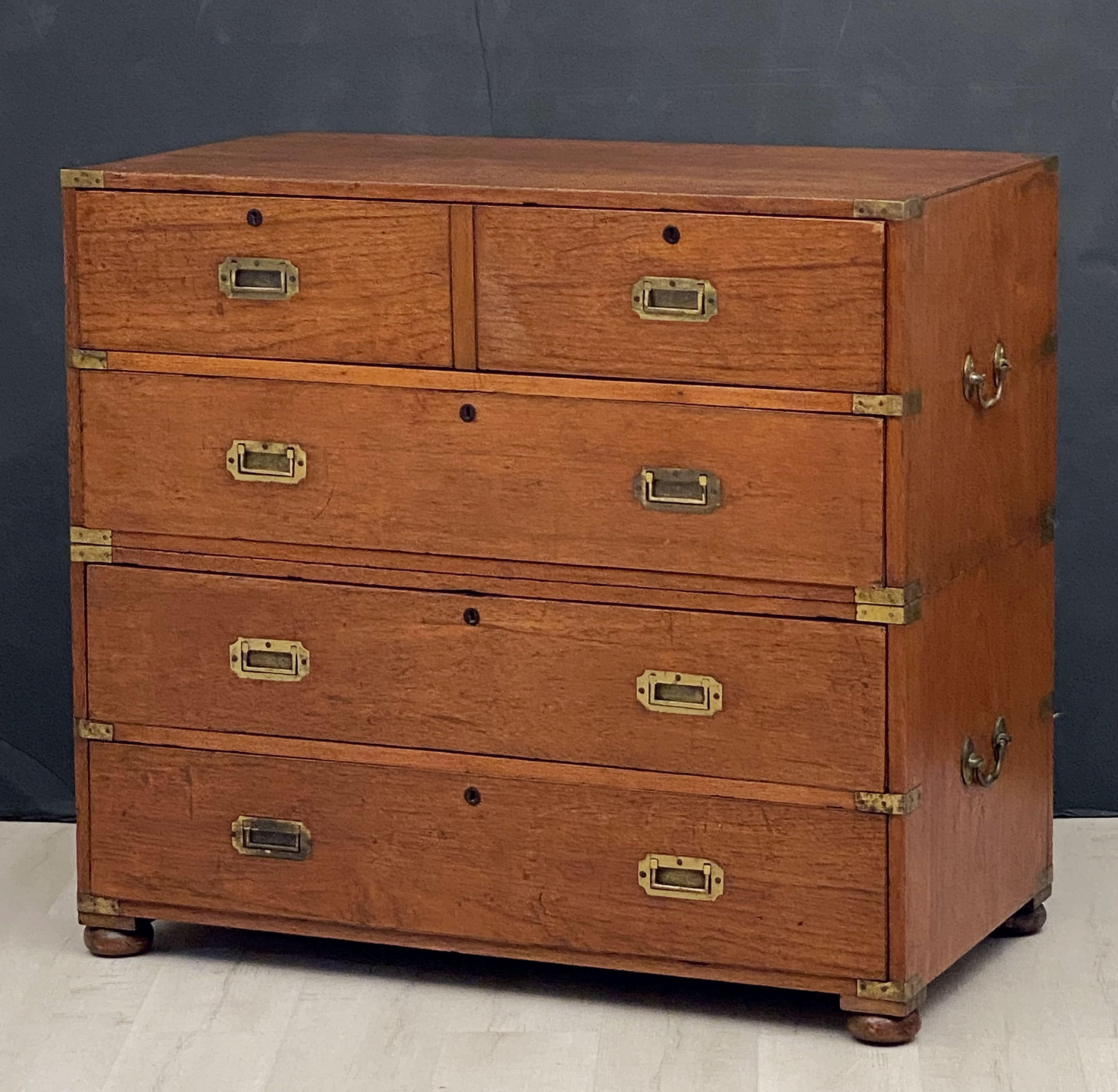 A fine English military officer’s Campaign ware secretary, fashioned as a chest of drawers, featuring a teak exterior, showing two short drawers over three long drawers. The top drawer with a faux facade of two short drawers, opening to a secretary