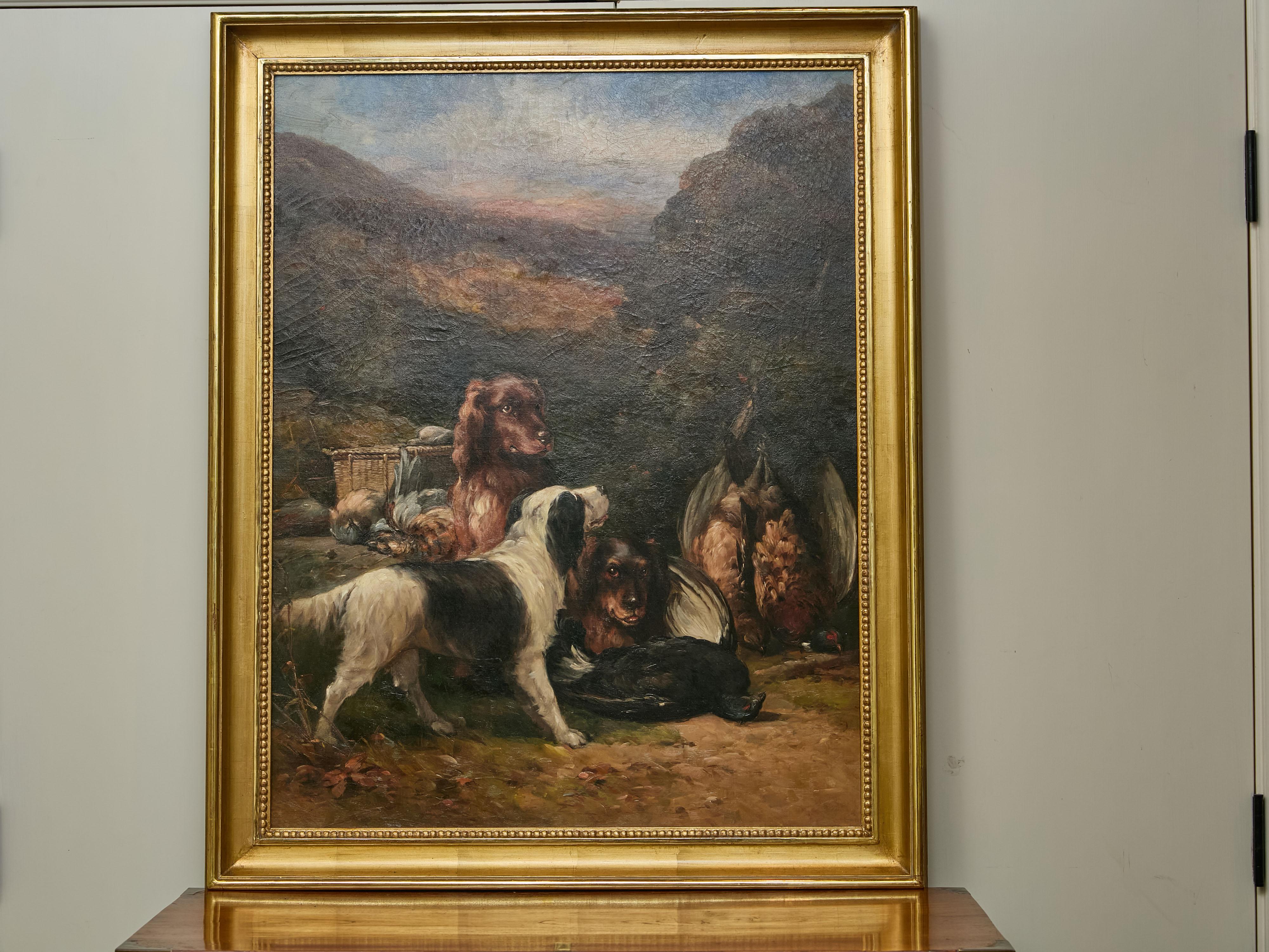An English oil on canvas hunt painting from the 20th century depicting three dogs and their catch, in carved giltwood frame. This English oil on canvas hunt painting from the 20th century captivates us with its dynamic composition and evocative use