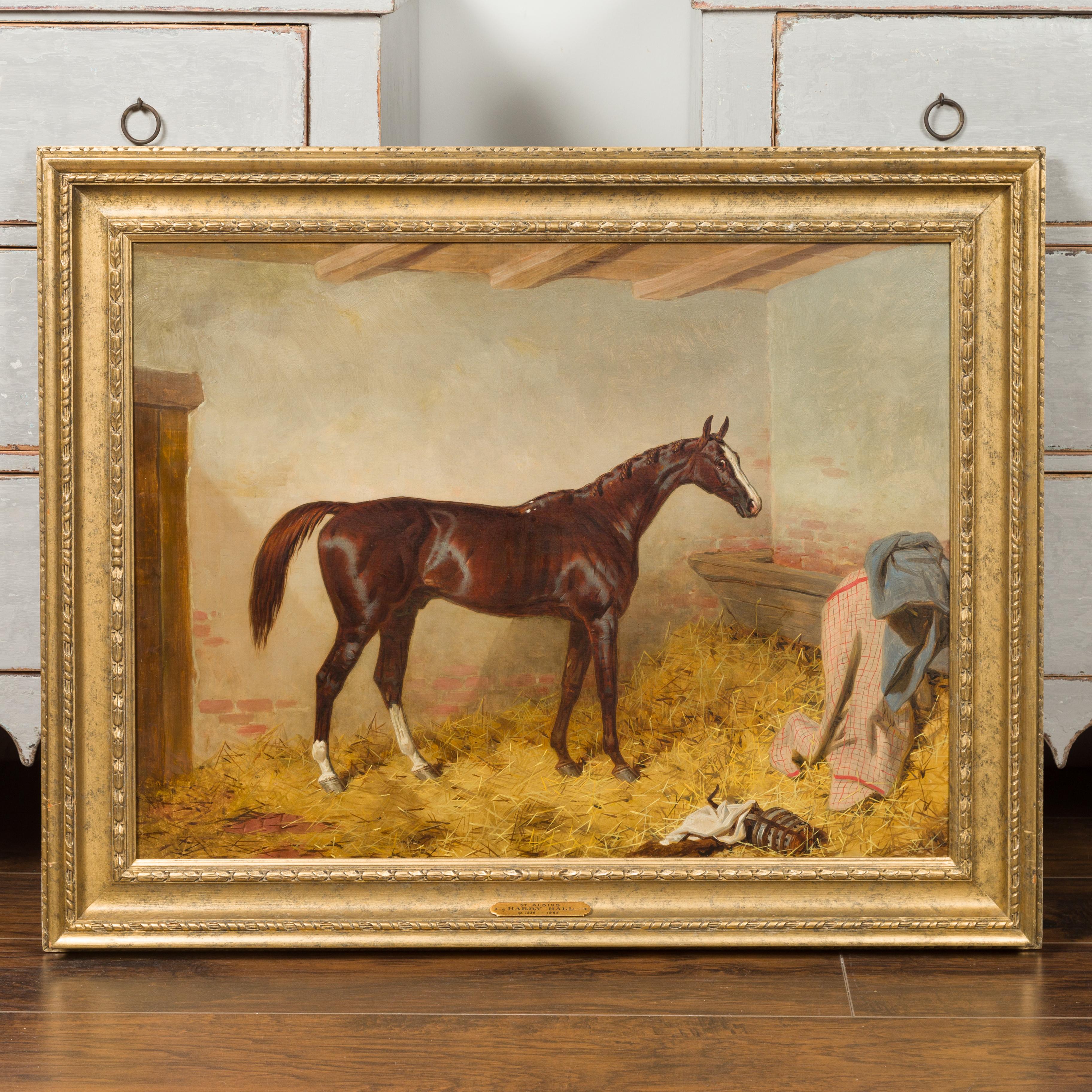 An English equestrian oil on canvas painting from the 19th century, attributed to Harry Hall (British, 1816-1882) in giltwood frame. This horizontal oil on canvas painting depicts the thoroughbred racehorse St. Albans in his stables. His shiny brown