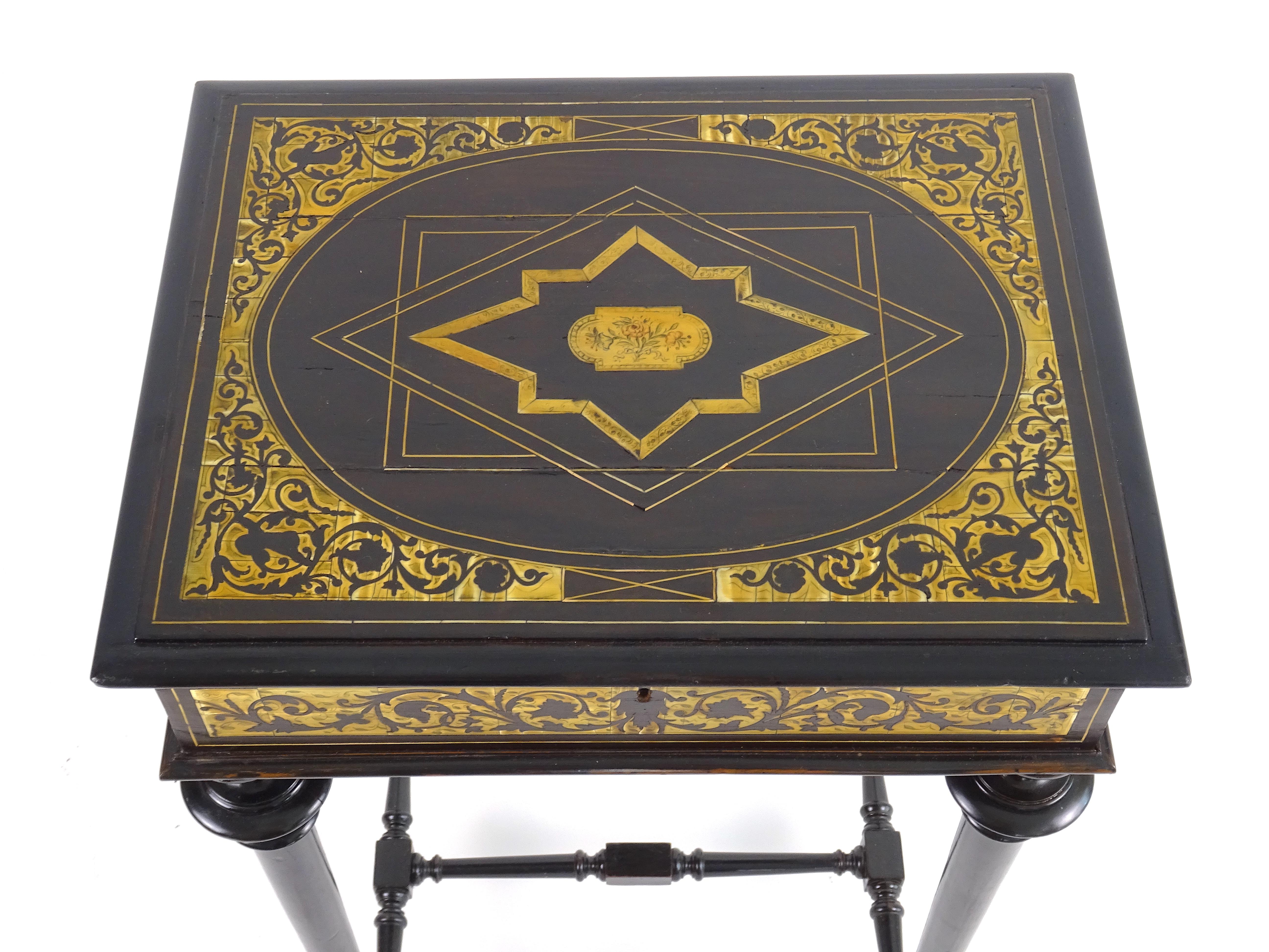 Small work table with opening top made of ebonized oak with inlaid details. On the top is a graceful geometric decoration containing within it a medallion painted with floral motifs, while the different sides also have decorations with naturalistic