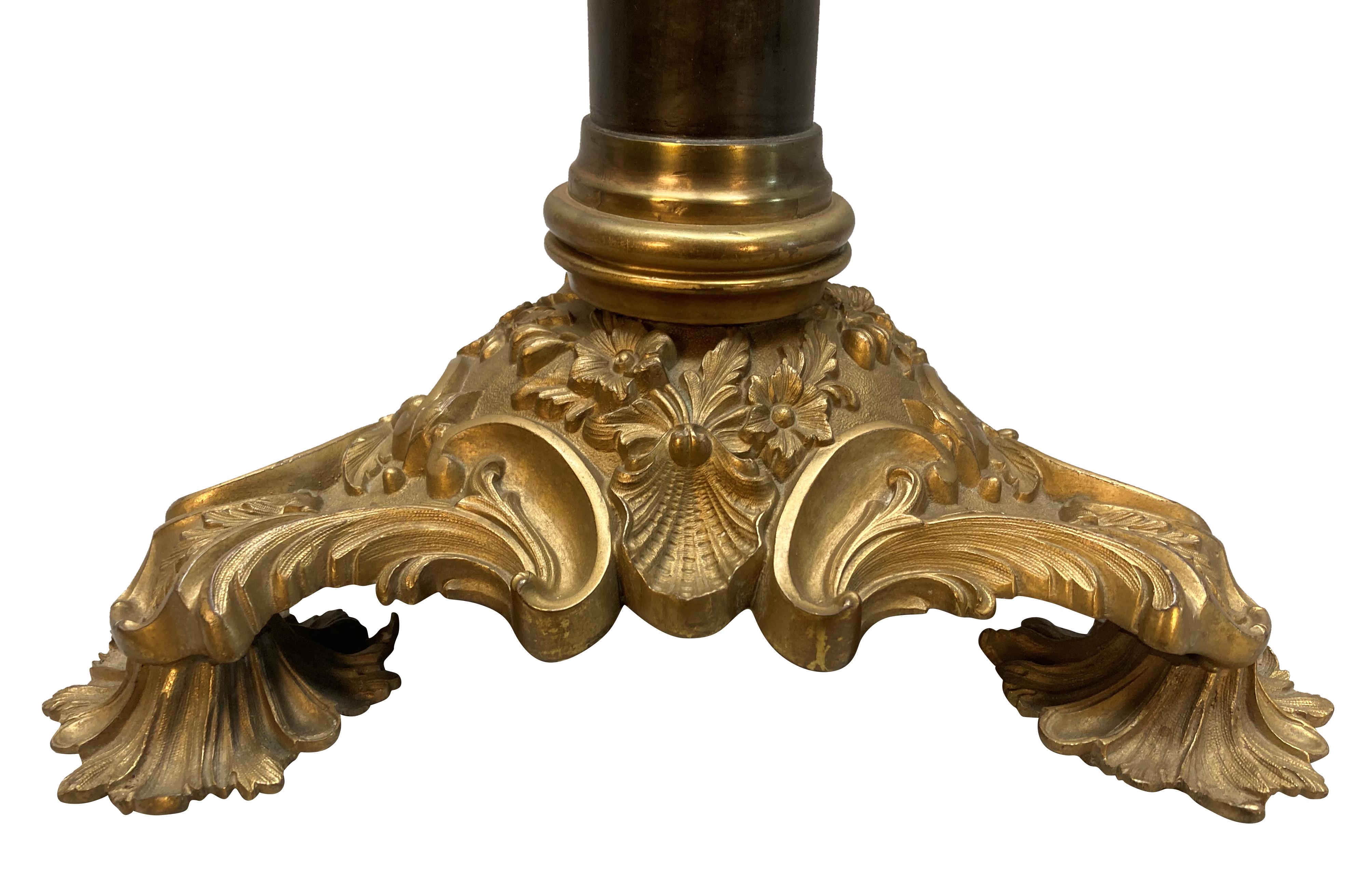 An English ormolu and bronze column table lamp on a triform base, formerly for oil.