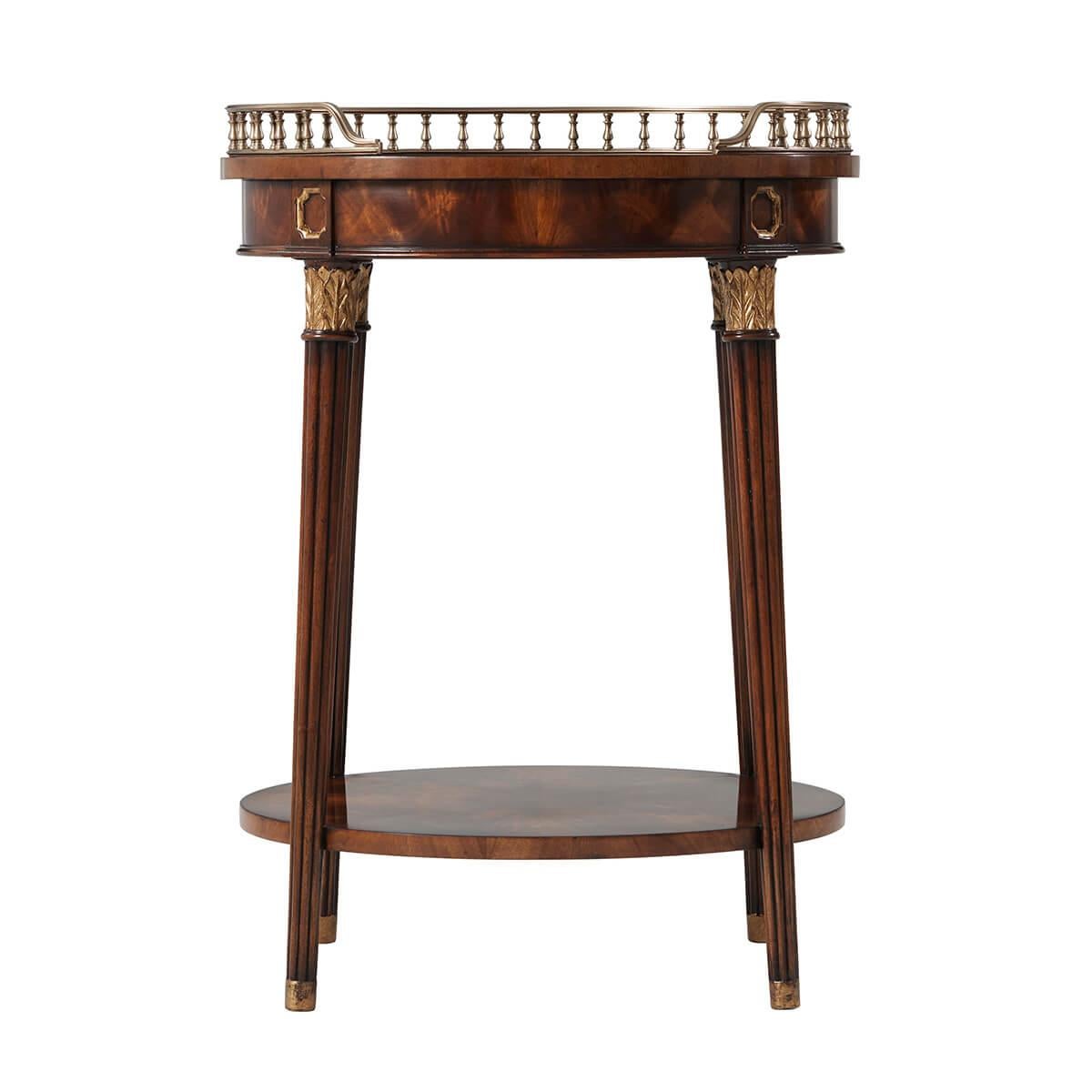 George III style figured veneer and mahogany side table. With an oval top with a fine three-quarter brass gallery, on splayed, gilt leaf capital, on reeded legs joined by a lower shelf stretcher.

Dimensions: 22