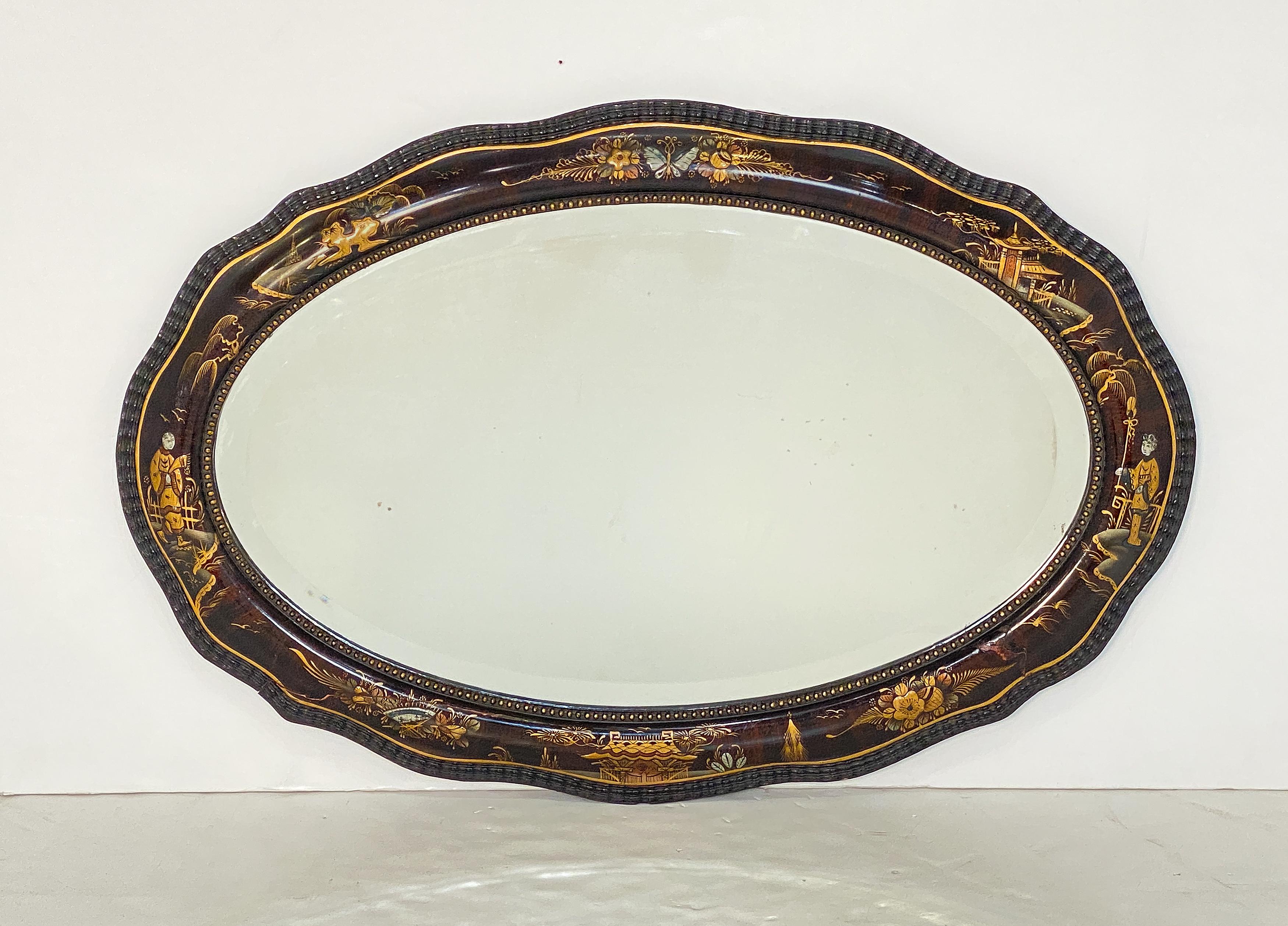 Un élégant miroir de salon ou mural anglais du 19e siècle - avec un cadre en bois de forme ovale et un bord serpentin en relief sur la circonférence, et un magnifique motif Chinoiserie laqué entourant le verre biseauté du miroir.

Dimensions H 22