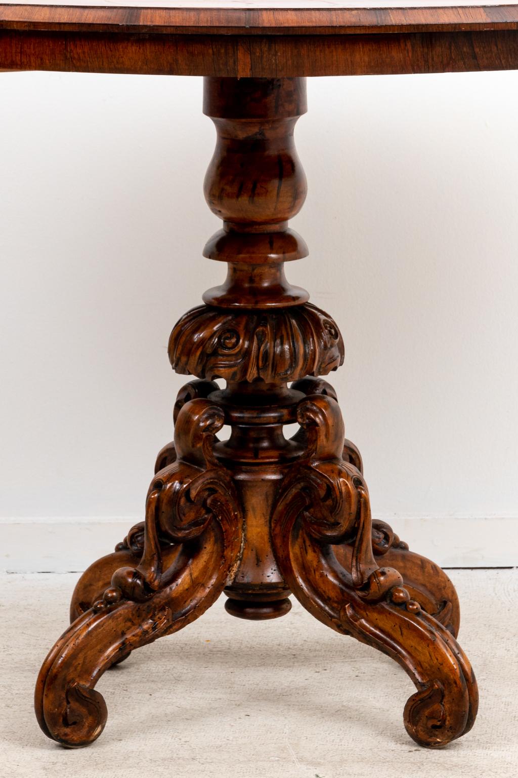 Circa 1900s English oval center hall table with carved vase-and-ring turned pedestal base on scrolled feet. Made in England. Please note of wear consistent with age.