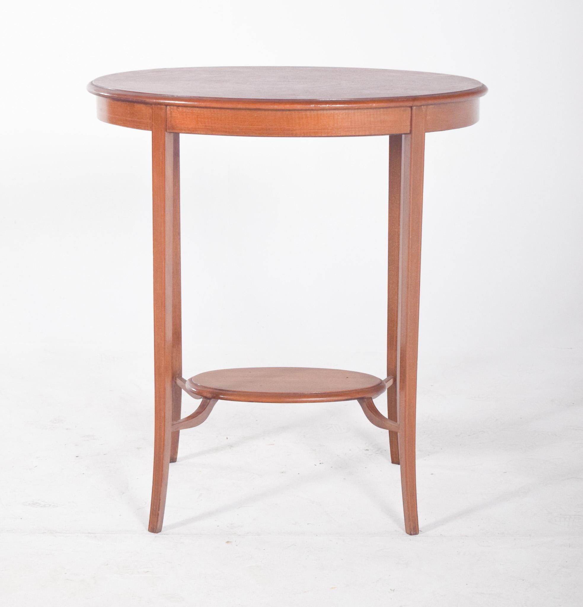 Oval coffee table with curved legs. With elegant lines and balanced proportions. It rests on four slender, slightly curved legs, which give the piece lightness and sophistication. It has an oval top with a recessed shelf and an intermediate shelf of