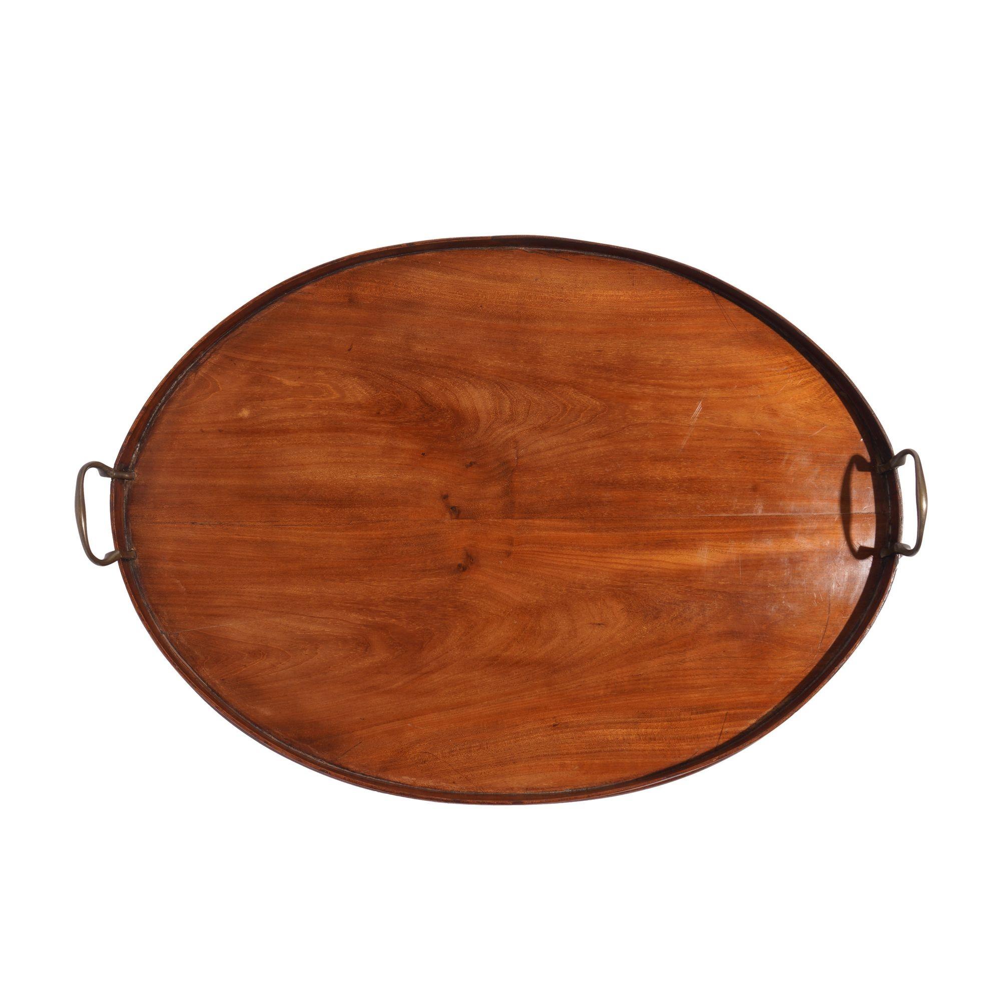 Oval standing rim mahogany tea tray with applied cast brass standing bail handles.
England, circa 1850-70.
