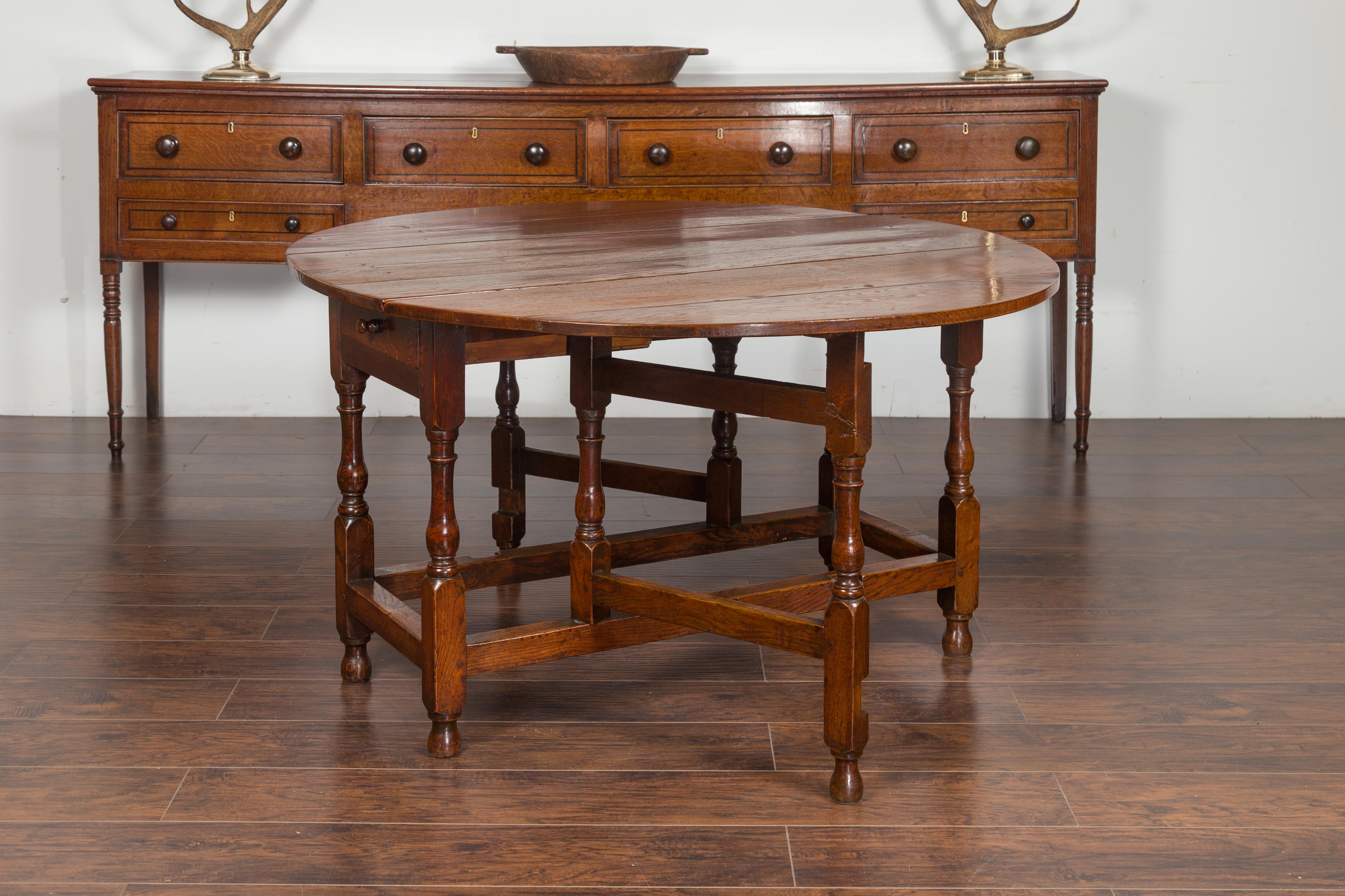 XIXe siècle Table à abattants anglaise en chêne ovale avec un seul tiroir et des pieds balustres en vente