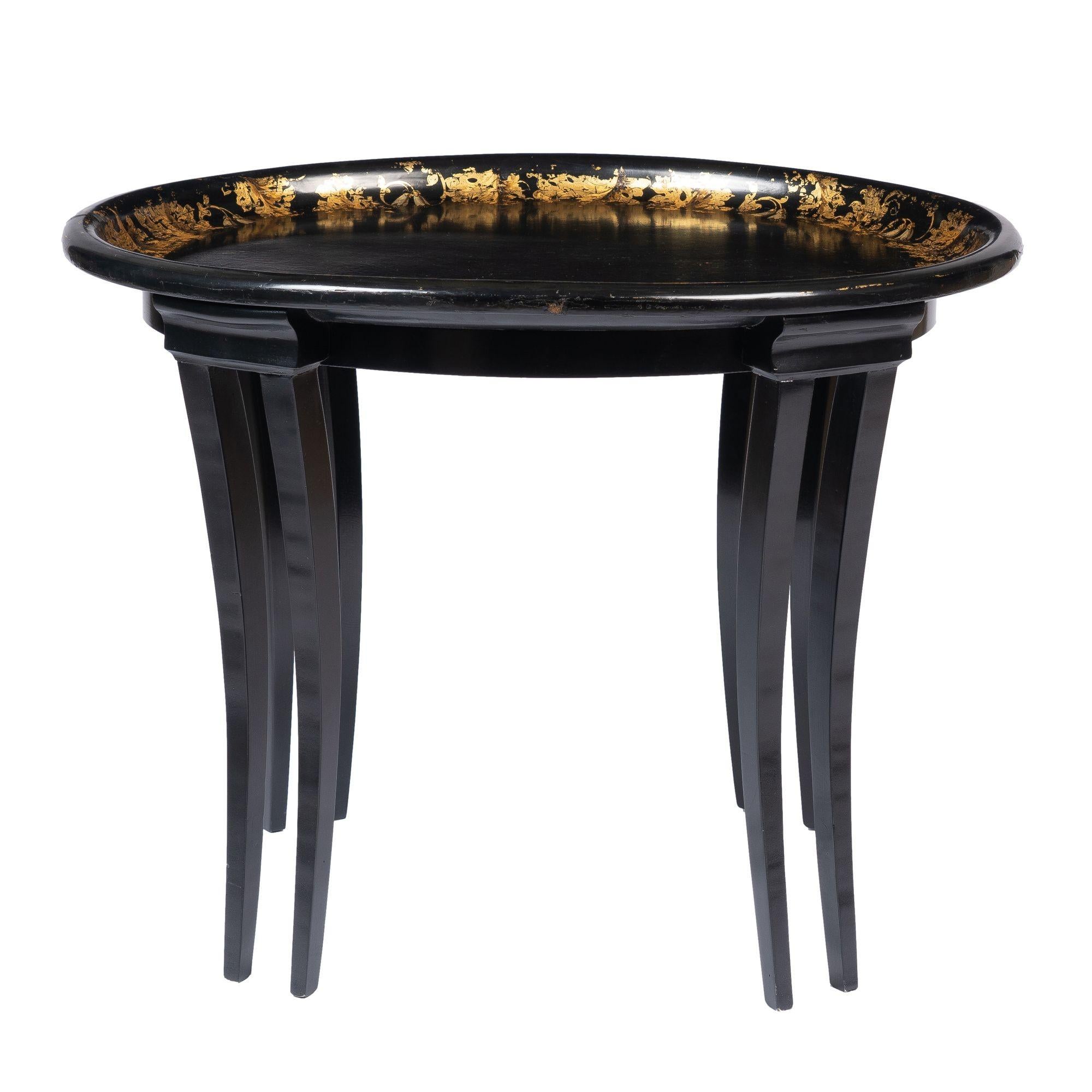 Oval black paper mache tray top coffee table with gold leaf border decoration, mounted on a custom sabre leg stand with conforming apron.

England, circa 1835.