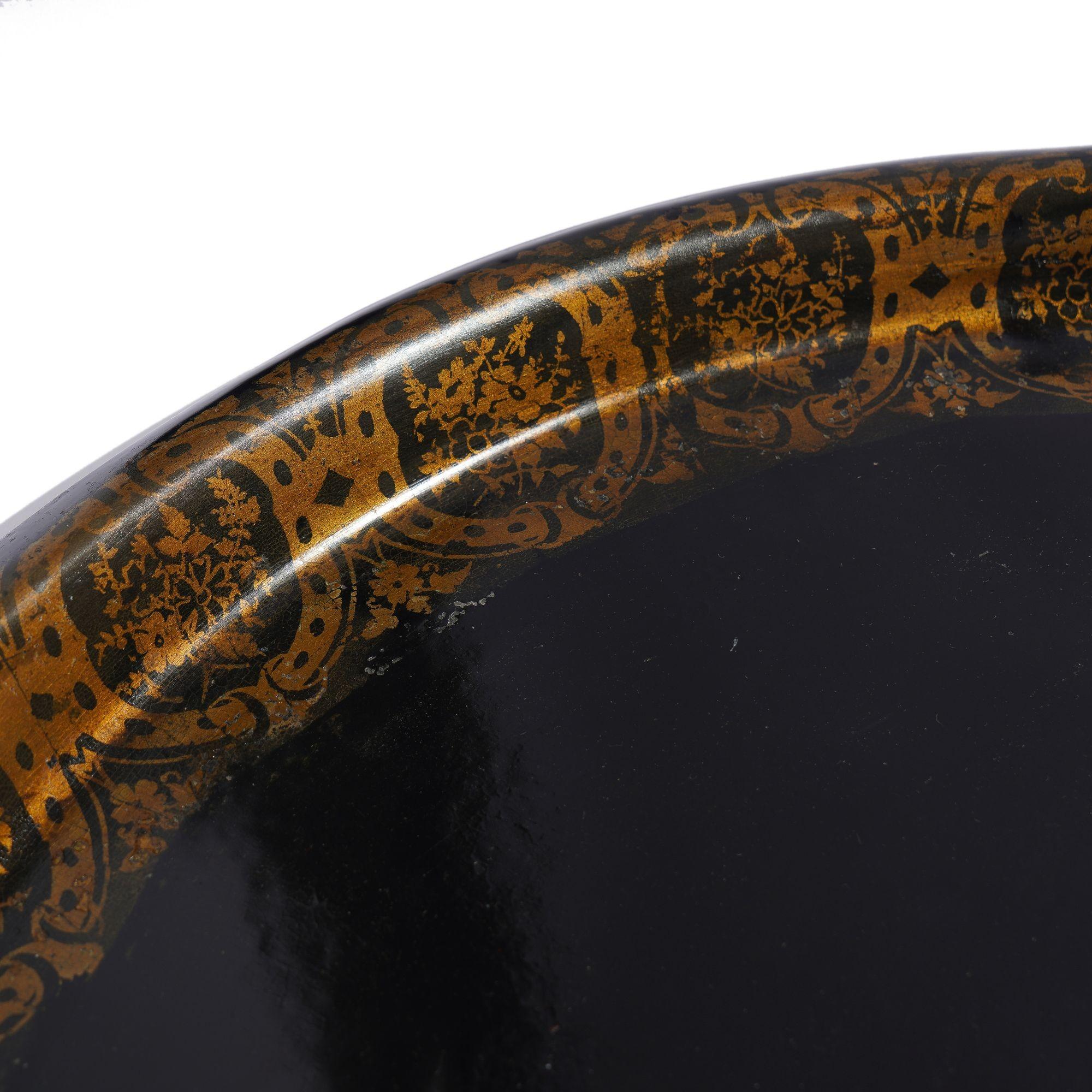 Plateau à thé tole ovale à bord roulé en noir avec un décor de bordure au pochoir en poudre de bronze. Les surfaces ont été nettoyées et polies.
Angleterre, vers 1840-60.