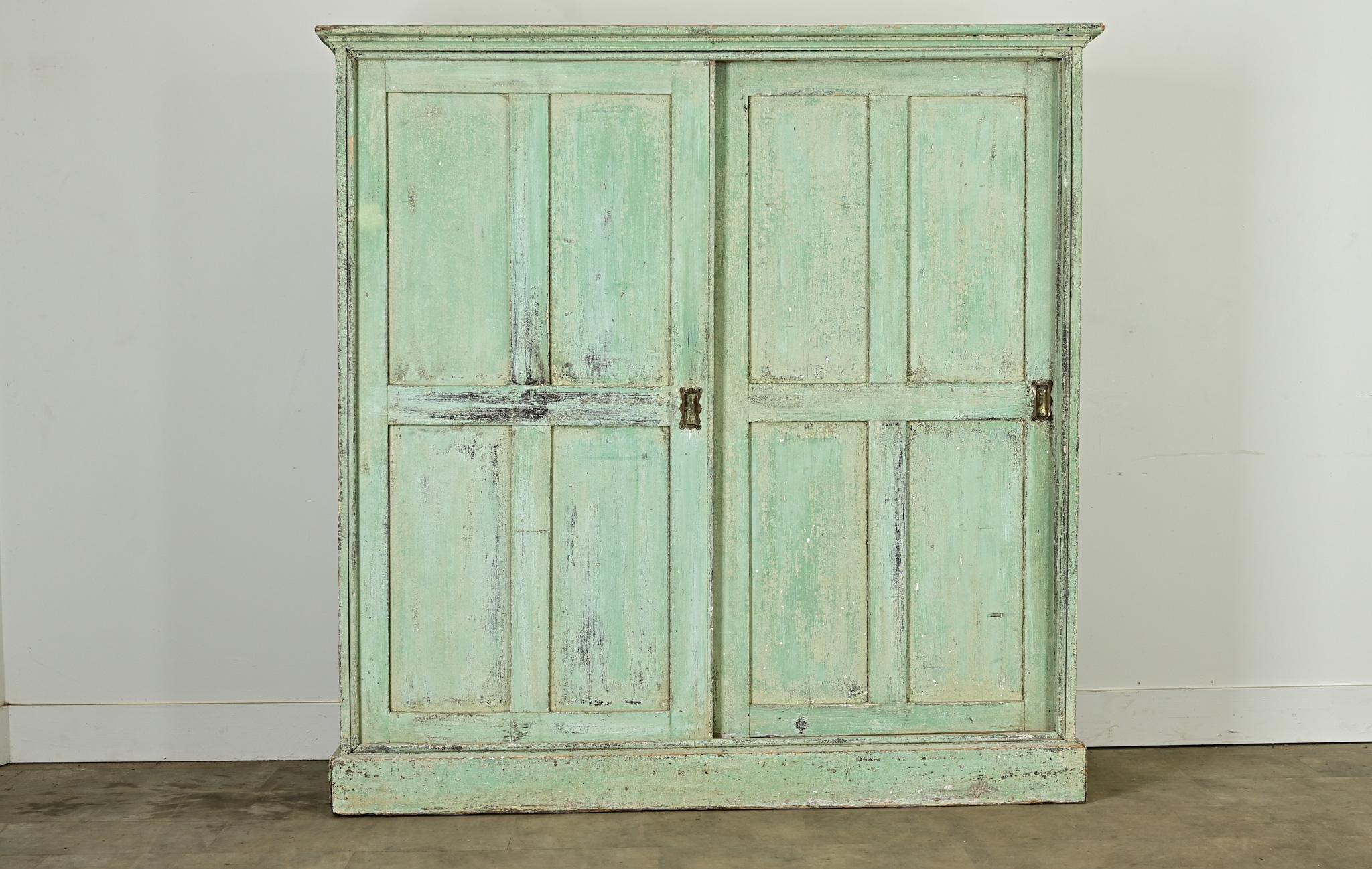 A delightful English larder, or kitchen cupboard, circa 1800 with original paint. The turquoise color of the cabinet’s exterior has patinated to exciting texture and tone, matched by the whimsical shape of the recessed flush door pulls. Two