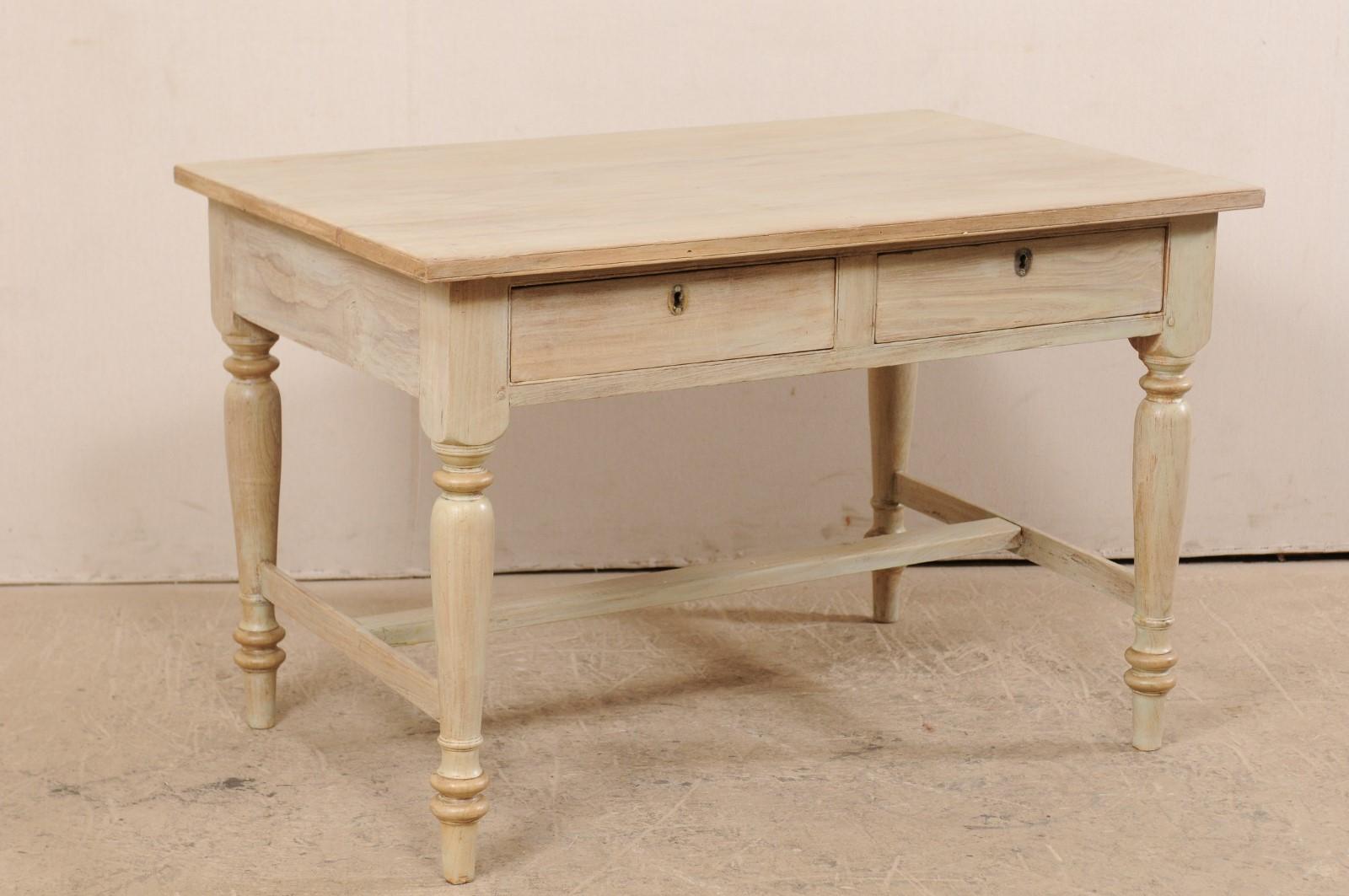 A vintage English occasional table with two-drawers. This table from England features a slightly overhanging and rectangular-shaped top, above a plain skirt which houses two drawers at one long side. Each of the drawer has three smaller divided