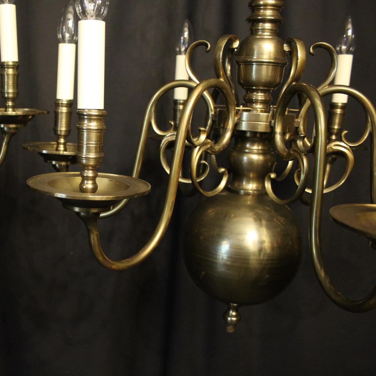 An English pair of bronze 6-light antique chandeliers, the scrolling arms with large stepped circular bobeche drip pans and reeded candle sconces, issuing from a knopped central column with ring finial, having the original chain and ceiling rose,