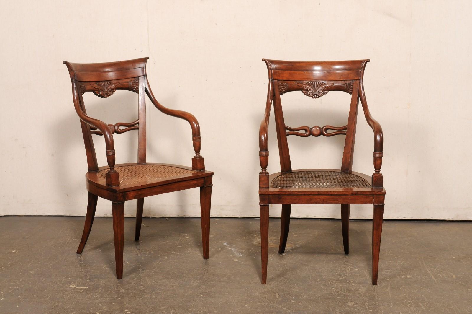Une paire de fauteuils en bois magnifiquement sculptés, avec des sièges en rotin, datant de la fin du 19ème et du 20ème siècle. Ces fauteuils anciens originaires d'Eleg ont un aspect léger et aéré, avec un dossier ouvert présentant une belle