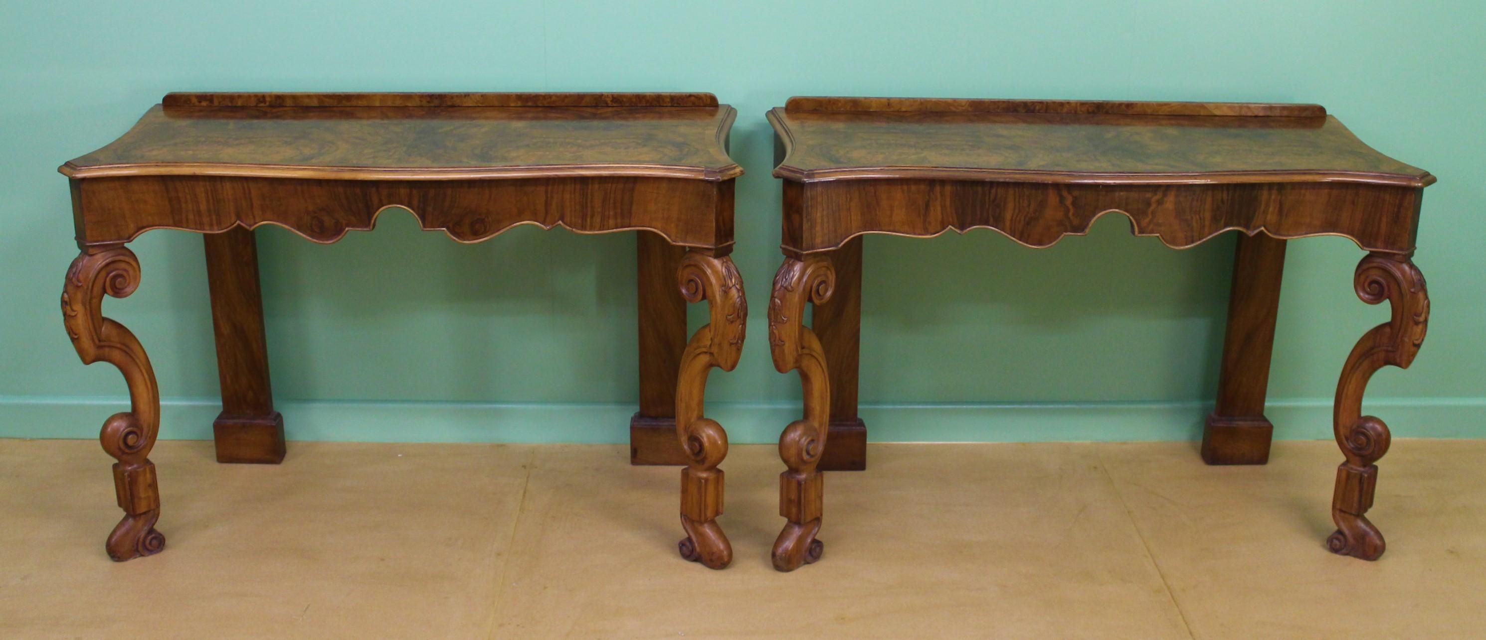 An impressive pair of console tables in attractive burr walnut. They are of good construction in solid walnut with lovely burr walnut veneers. They have been adapted from a larger table. They are of serpentine form with stylish scrolling front legs.