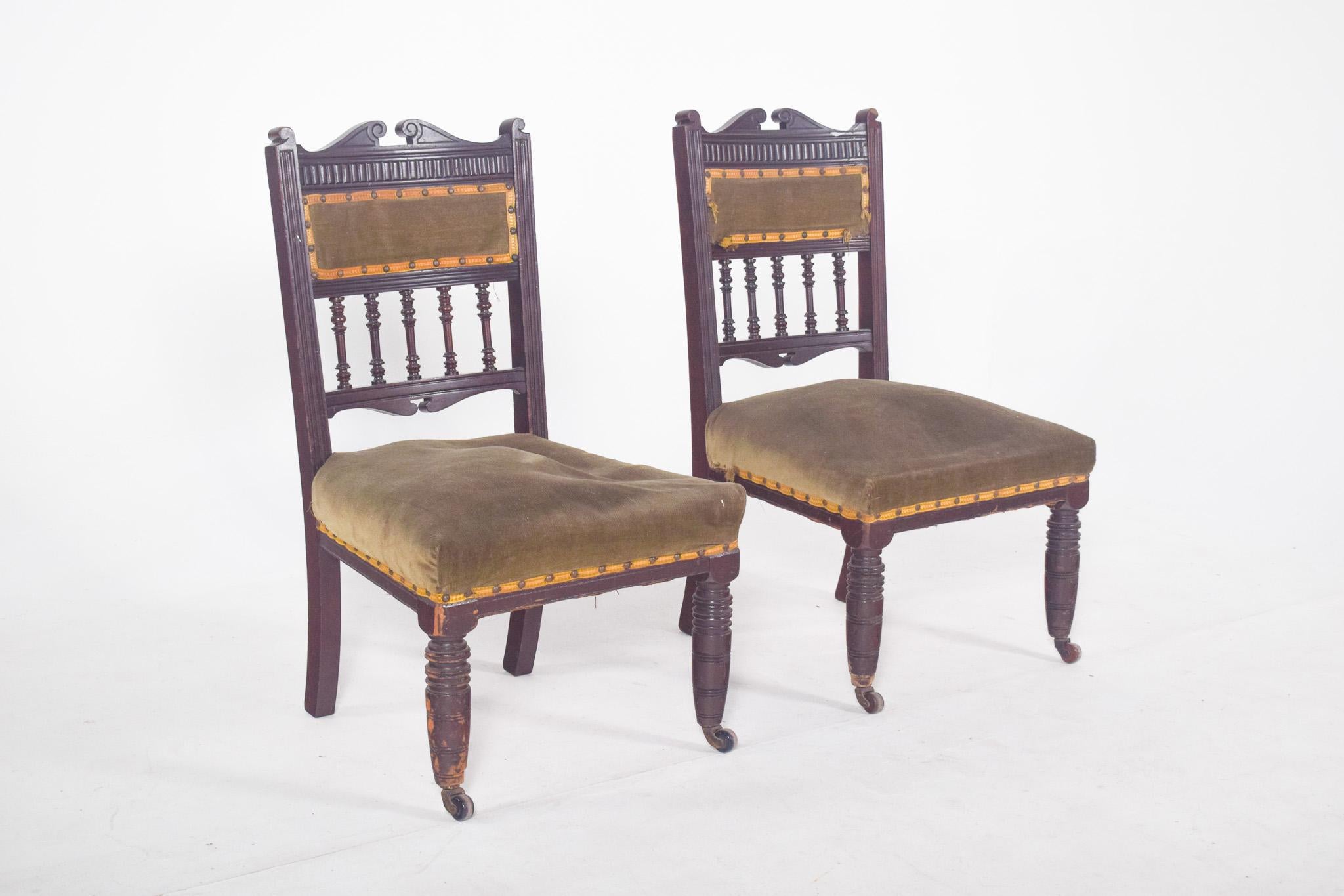 Paire de chaises pour vieilles dames. Avec une assise et un dossier tapissés de velours vert, le dossier est constitué d'une bande centrale tapissée flanquée de petites colonnes tournées et terminée par une finition supérieure en volutes sculptées.