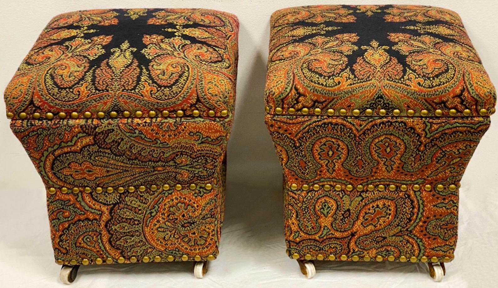 This is a pair of petite English upholstered storage ottomans on tiny castors. The paisley fabric is in very good condition as is the pink interior. They date to the 40s.