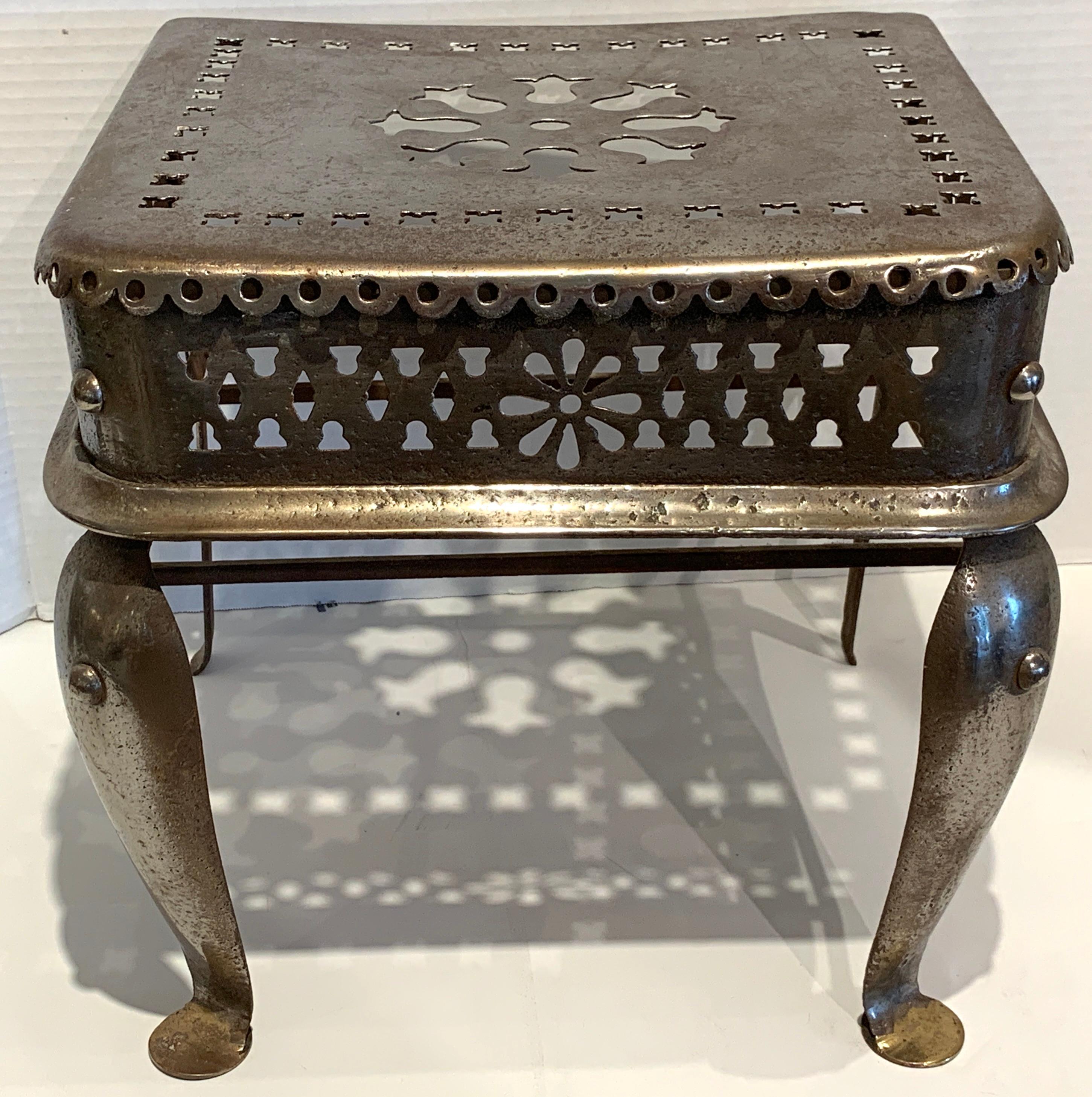 English Paktong fireplace footman / stand, with all-over pierced decoration, raised on four pad footed legs. Used for fireplace fire stool English hearth stand, fireside trivet, or even a coach step.