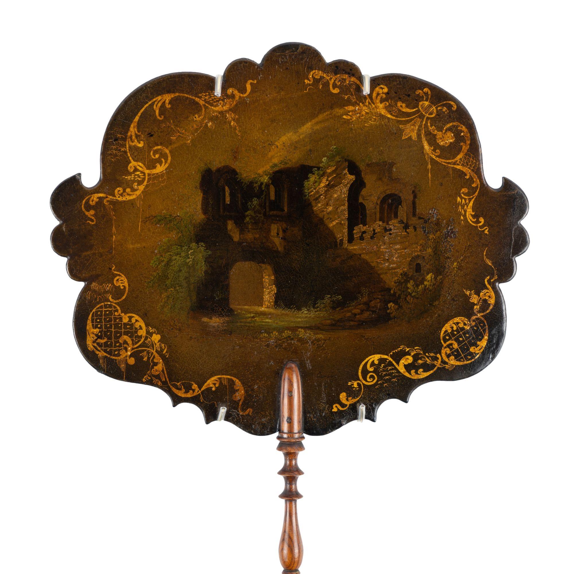 Sculptural papier maché face fan with a beautifully turned rosewood handle. These screens were used by women to shield their face from the heat as they sat close to the fire in colder months. The fan is decorated with a scene of English Gothic ruins
