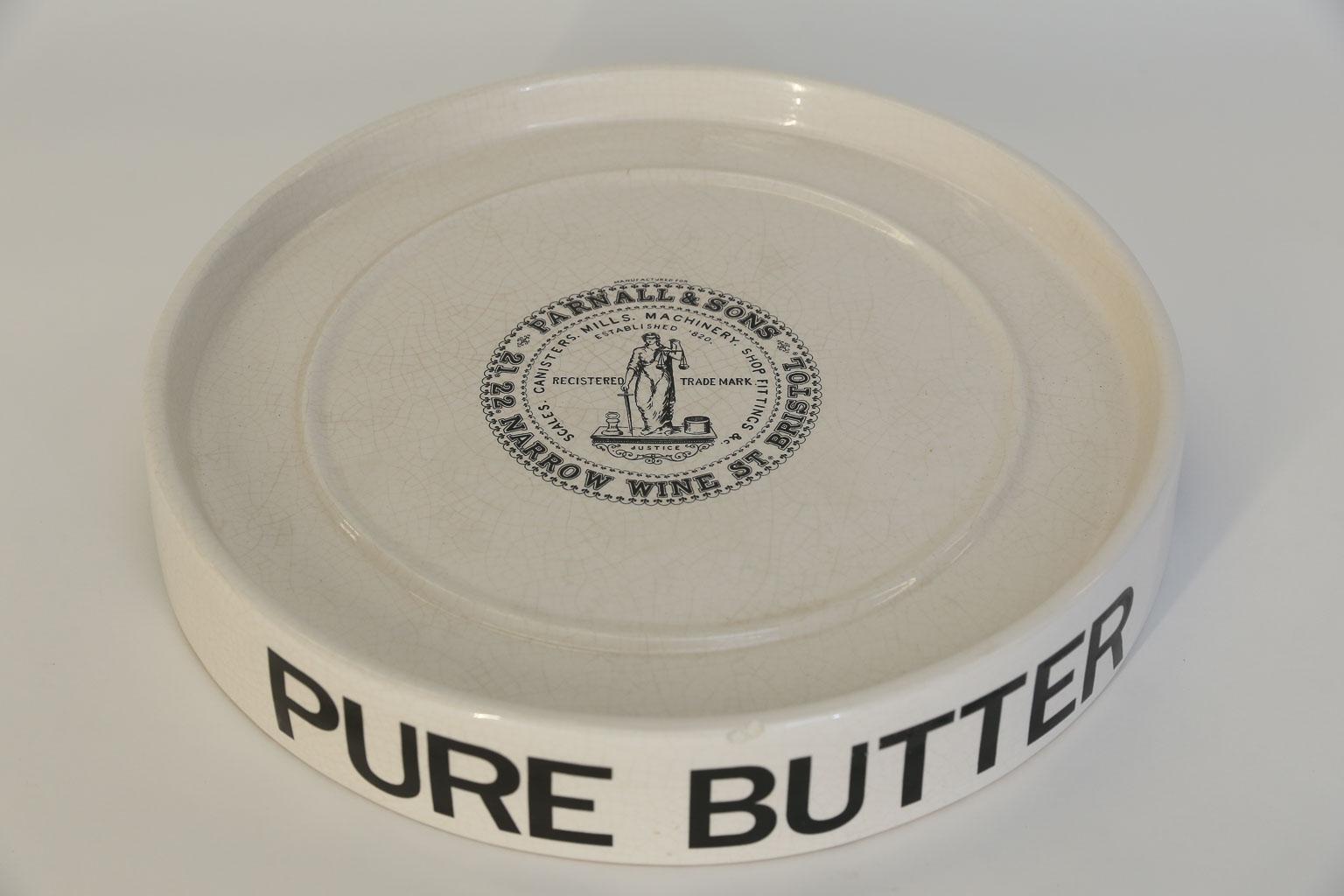 This is a mid-20th century pure butter dairy slab originally used for displaying butter on the dairy shop counter in England. The decorative advertising is printed in black on the side reading PURE BUTTER, and the top has the Parnall & Sons logo. A