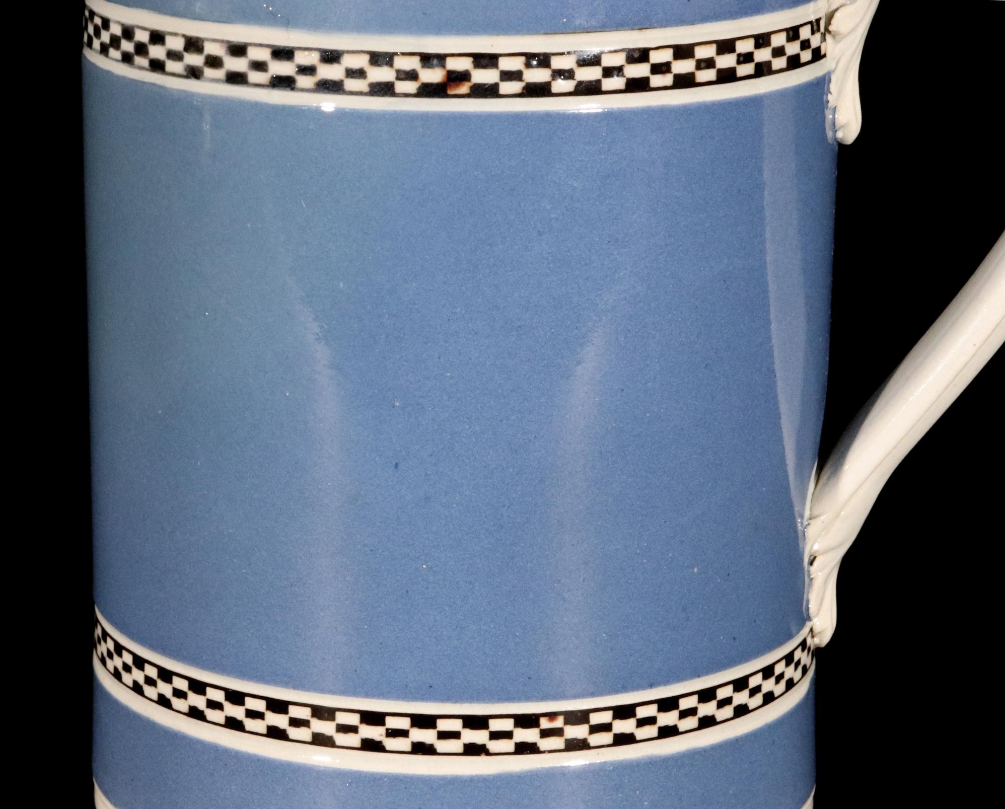 English Blue Ground Pottery Mocha Mug
Late 18th Century

The  blue ground slip tankard with a white handle with leaf terminals has two bands of molded checkerboard black and white bands.

Condition Good with no restoration. There is a dot to one