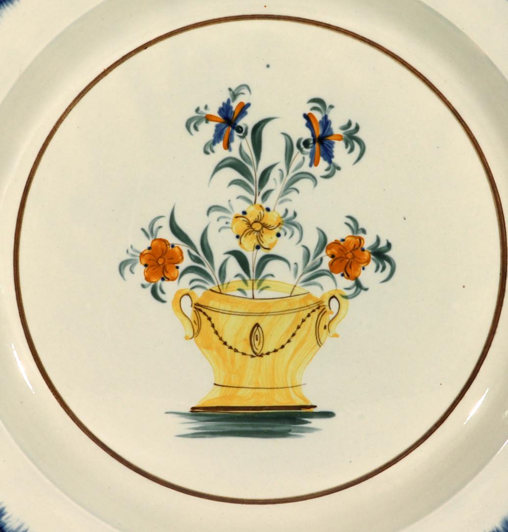 English pearlware pottery large dish with strawberry decoration,
Circa 1800-1810

The large English pearlware pottery circular dish is painted with a yellow urn filled with flowers with two large tall blue flowers. The rim with a stunning blue