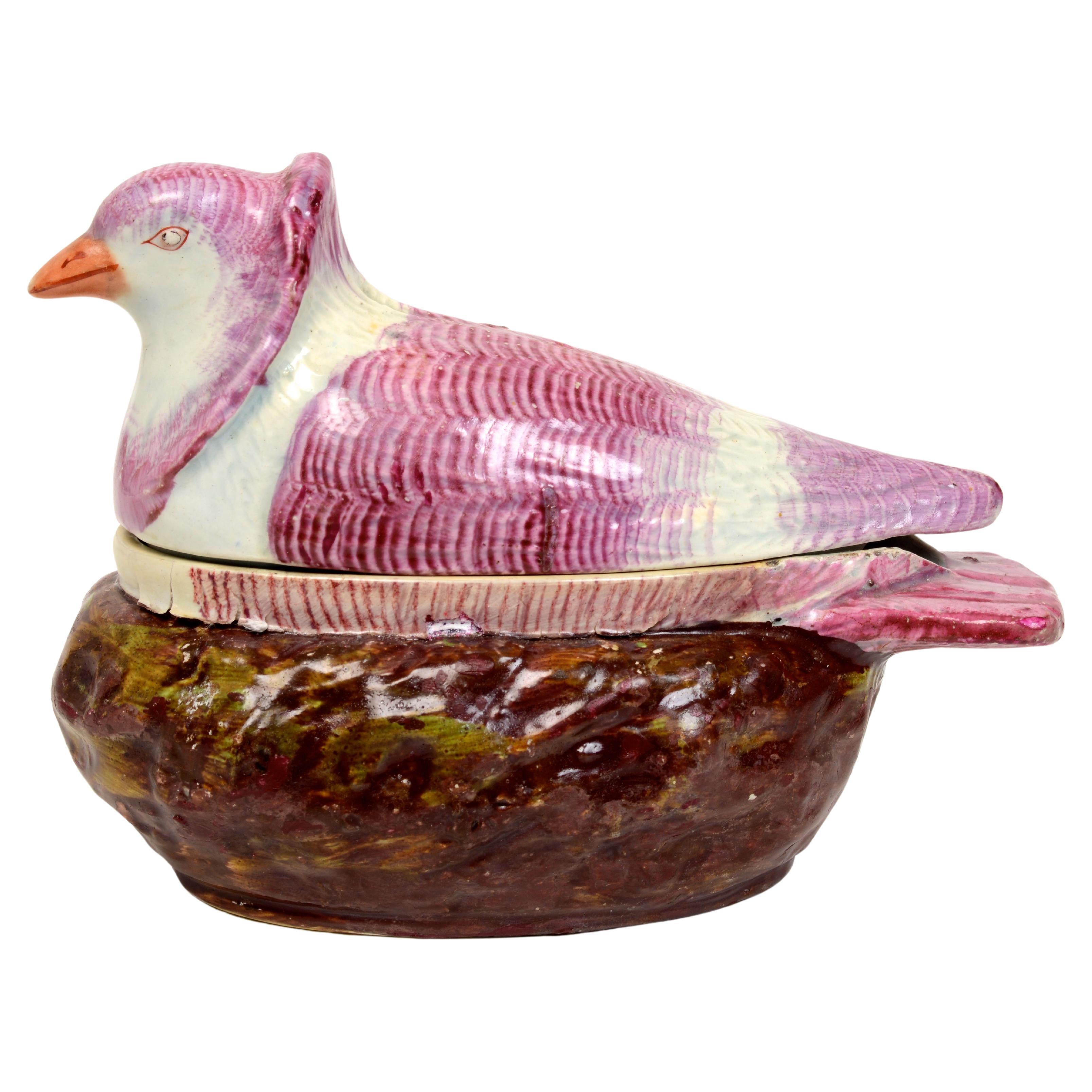 An English pearlware polychrome painted tureen-box and cover in the form of a nesting turtle neck dove, early 19th century. Naturalistically modeled and painted in shades of pale purple, its nest applied with 'moss' and painted in tones of brown and