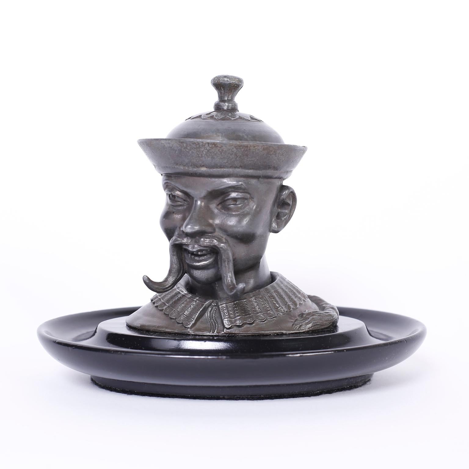 Antique English cast pewter inkwell of an Asian scholar sporting a Fu Manchu mustache and ponytail, fixed to a lacquered wood tray.